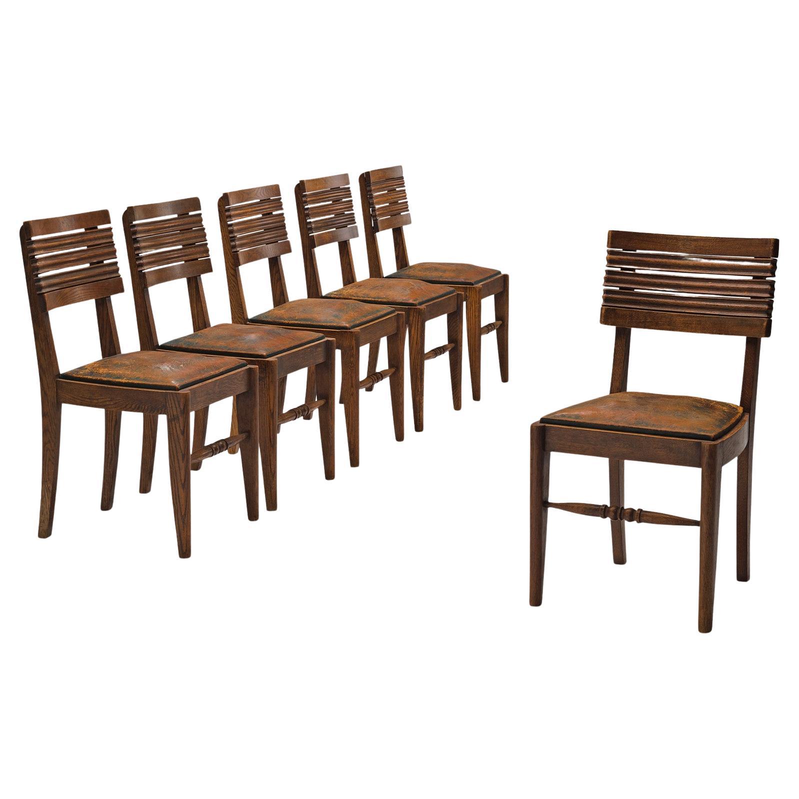 Gaston Poisson ensemble de six chaises de salle à manger en chêne et cuir 