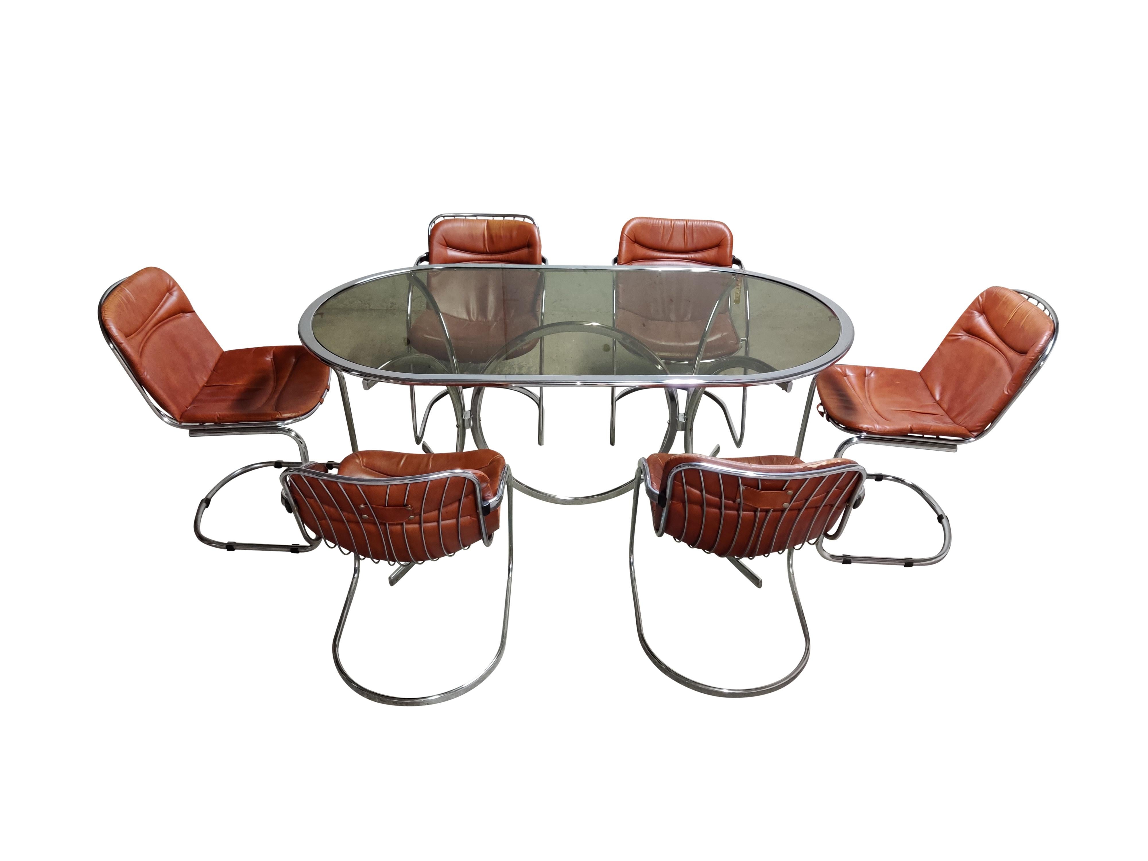 Vintage dining room set by Gastone Rinaldi for Rima Italy.

The set consists of one chrome table with an oval smoked glass top and six leather chairs (4 with armrests and two without).

The table is in good condition with patina and undamaged
