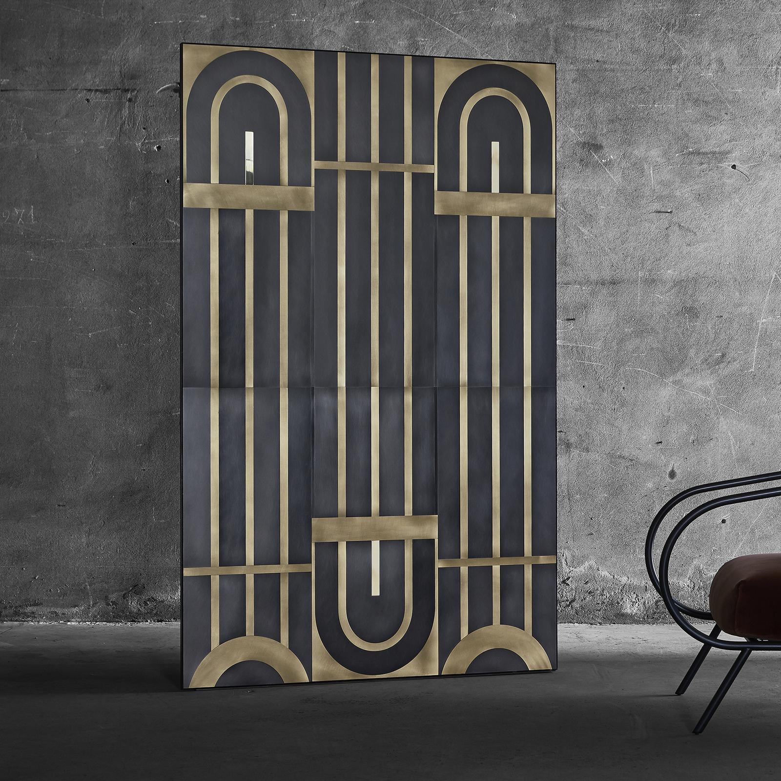 Inspired by the gates of the 1930s historic Milanese buildings, this brass covering has a multi-dimensional and architectural quality. The arches and lines of the design in bright gold over a black background have a tactile finish and visual depth
