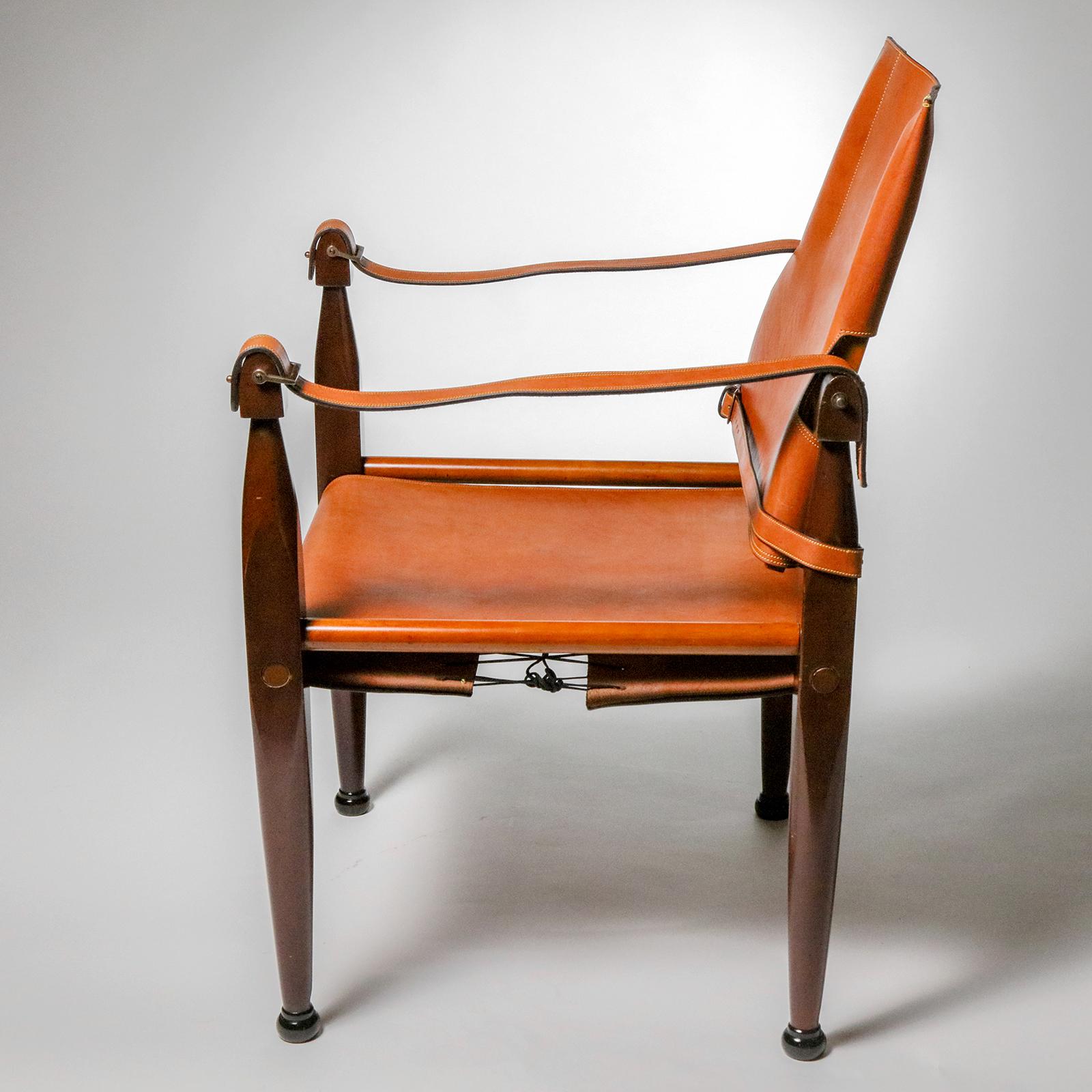 A distinctive cognac-colored leather accent chair, so-called because of the stitched bridle strap arms and leather buckle detailing that recalls the famous Spanish cowboys (gauchos). Dark maple wood frame in distressed finish completes the look.