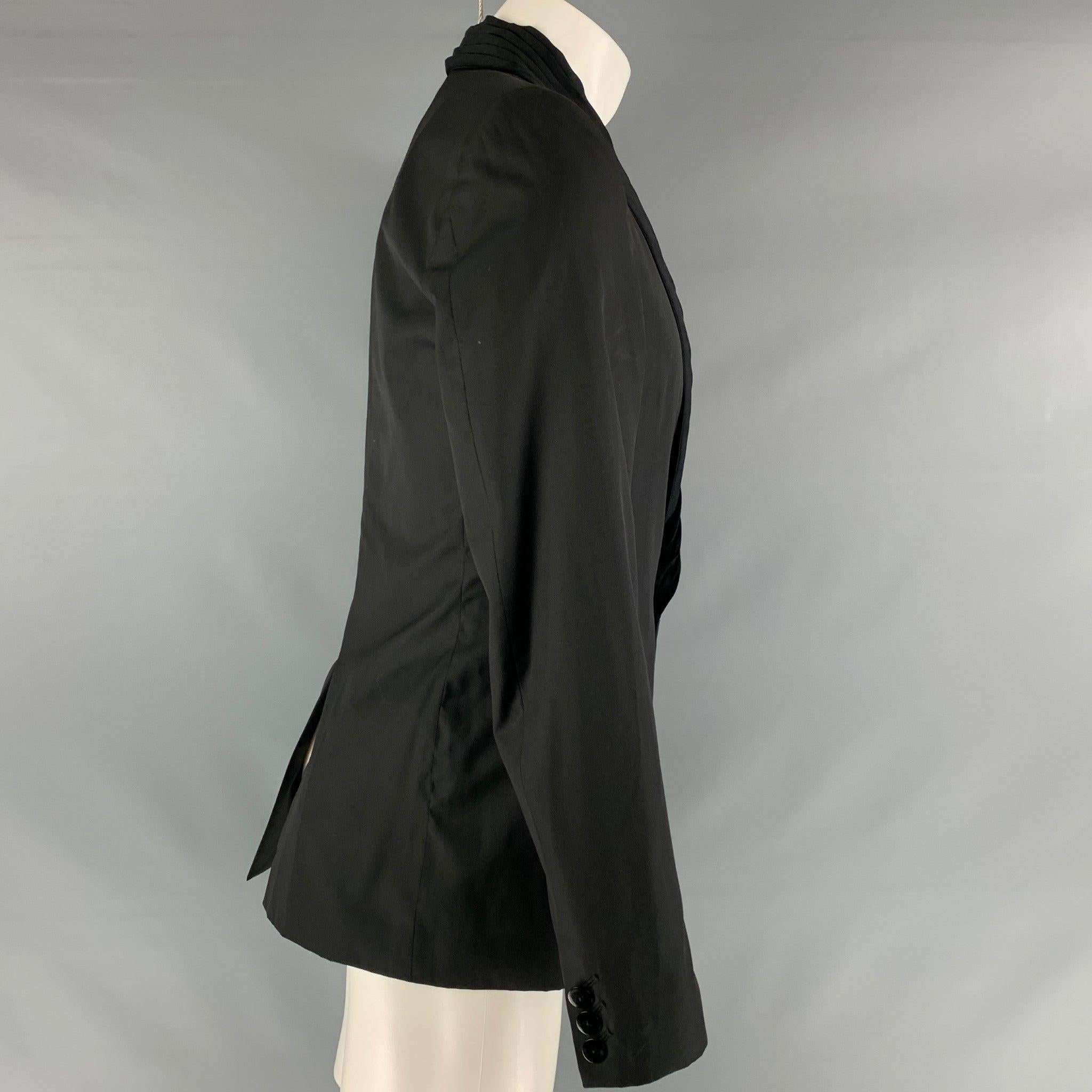 GAULTIER2 by JEAN PAUL GAULTIER sport jacket comes in black wool and silk woven material featuring a pleated lapel, single button closure, welt pockets, single back vent, and signature tab detail.
Made in Italy.Very Good Pre-Owned Condition. Minor