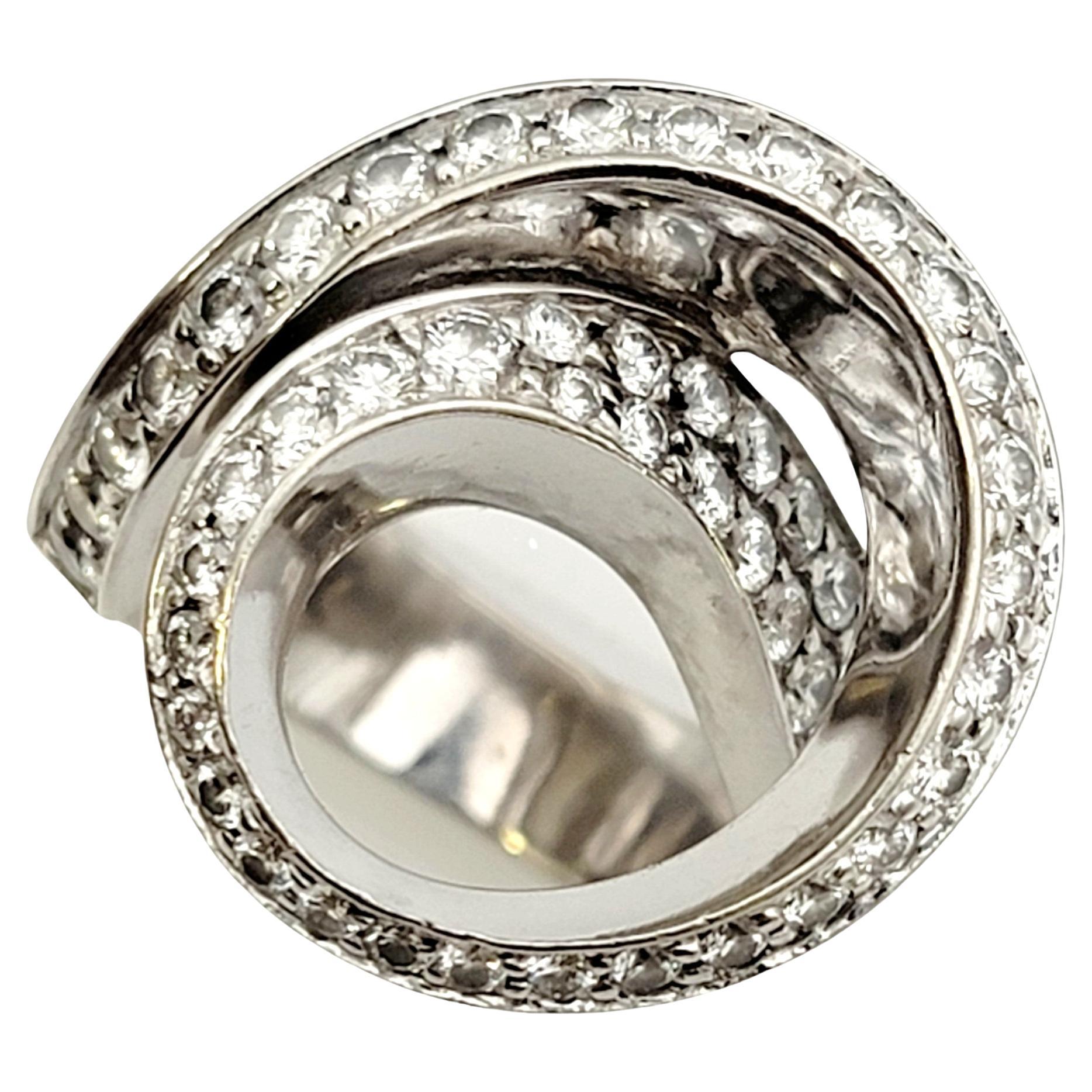 Ring size: 8

Gorgeous, one of a kind white gold swirl ring embellished with dazzling, bright white diamonds by designer Gauthier. This bold, artsy ring is set in an asymmetric open swirl pattern, sitting high off the finger and filling it with