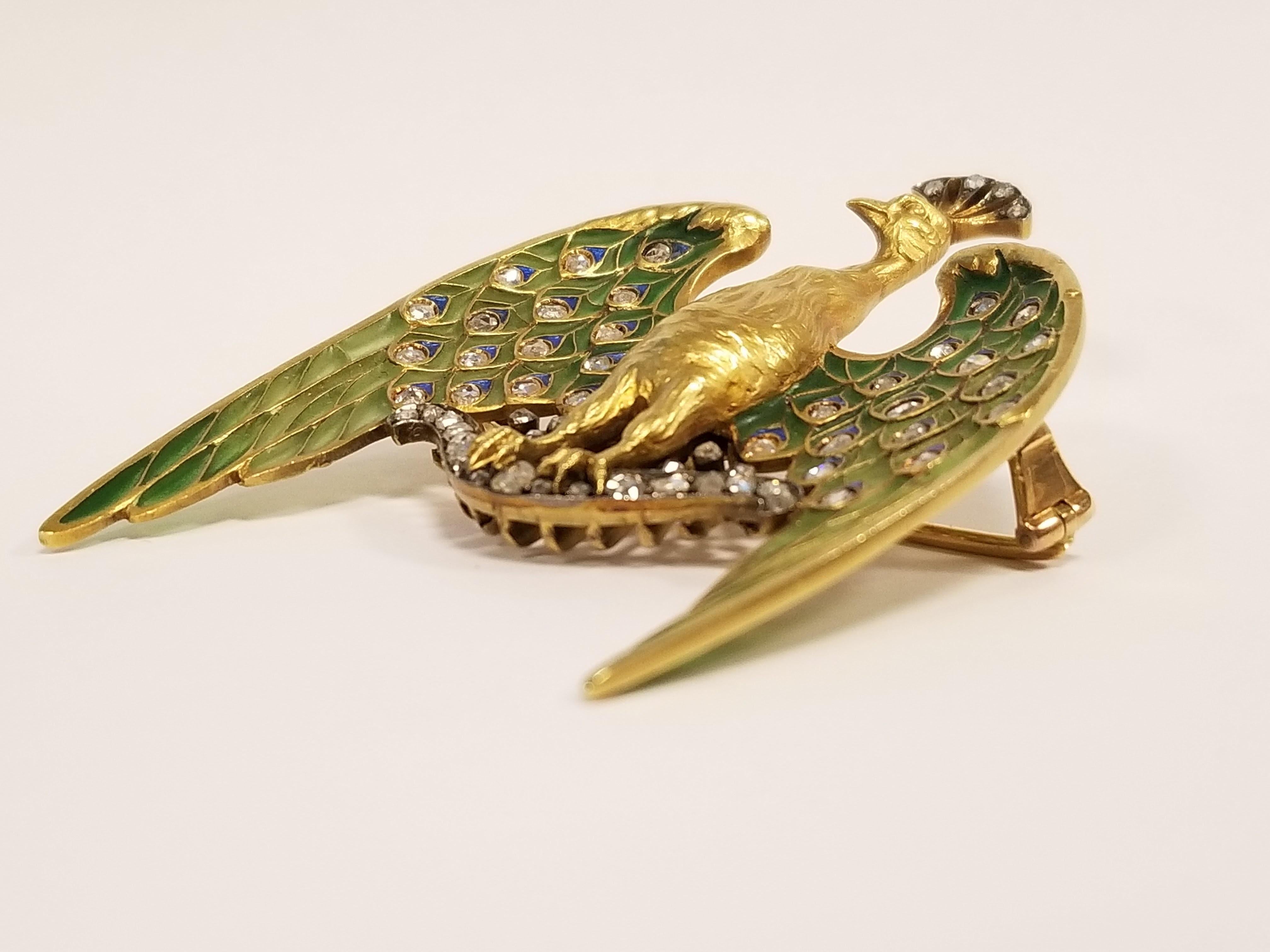 A French Art Nouveau 18 karat gold, silver and plique a jour enamel peacock brooch pendant with diamonds by Lucien Gautrait. The peacock has 61 rose-cut diamonds with an approximate total weight of 1.35 carats that are set in plique a jour
