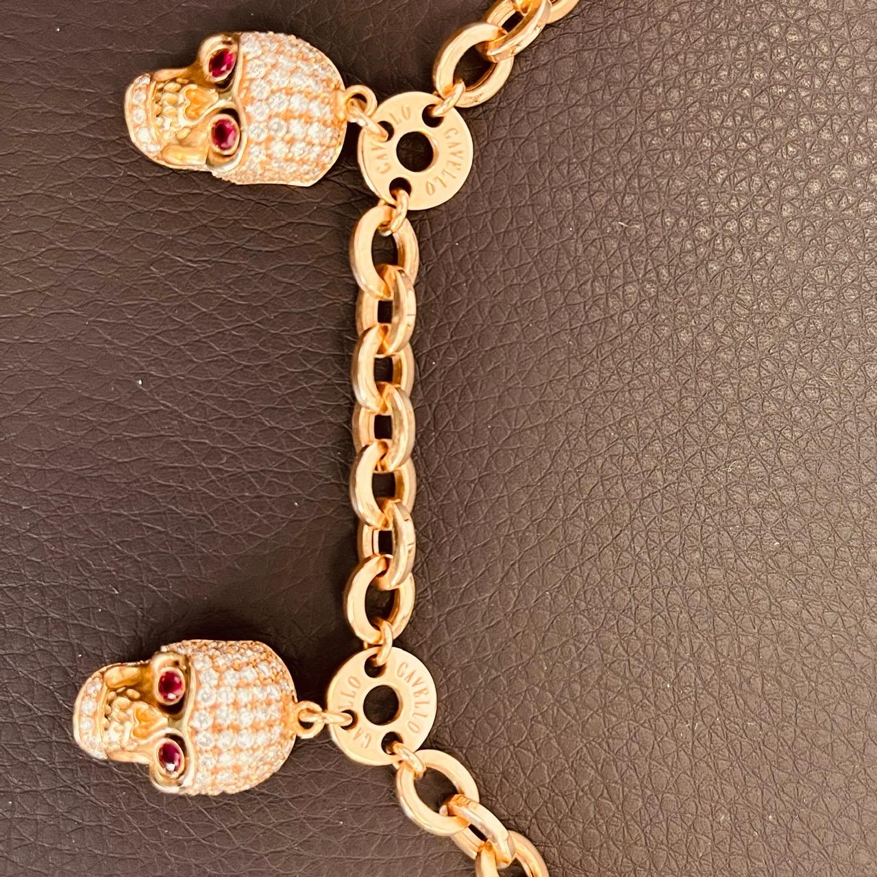 Gavello 18ct gold, 2.2ct diamonds and 0.5ct ruby eye skull necklace. The oval links and round branded discs suspending 4 pink enamel backed skulls all with ruby eyes - two in polished gold and the two pave set to a large lobster clasp. Chain width
