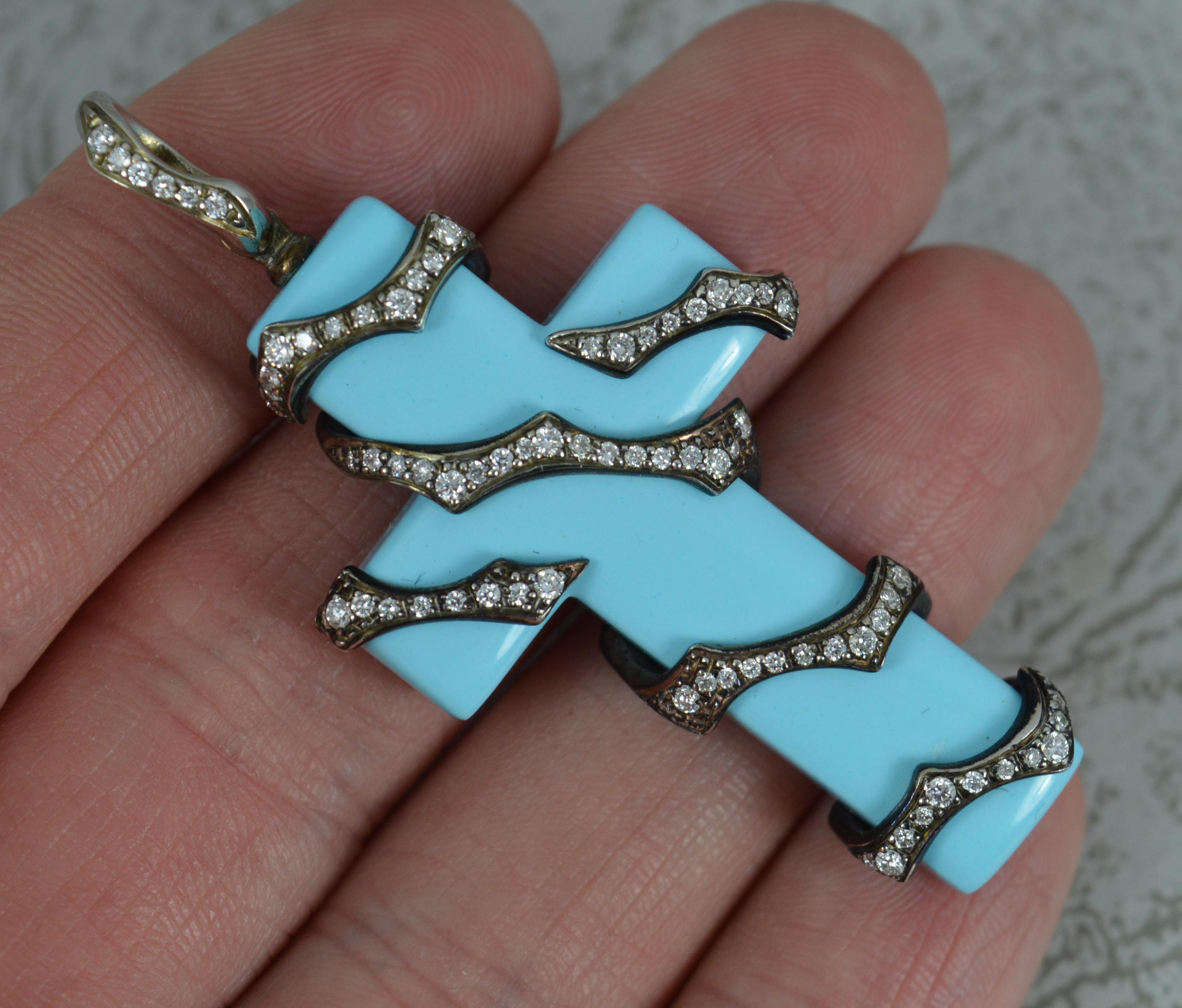 A fantastic Gavello designer cross pendant.
Solid 18 carat gold example. White gold example with blackened finish.
The cross made from turquoise and set with many round brilliant cut diamonds to the gold setting to front.

CONDITION ; Excellent.