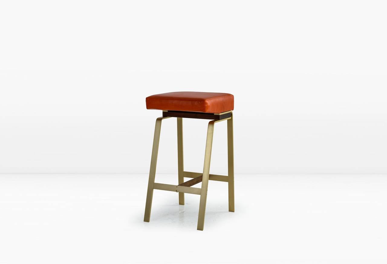 The asymmetry of the Gavilan as well as its unusual juxtaposition of materials has made it a KGBL icon. Shown with a Solid Brass base with American Black Walnut details and Tomato leather seat. Also available as a counterstool and with a backrest.