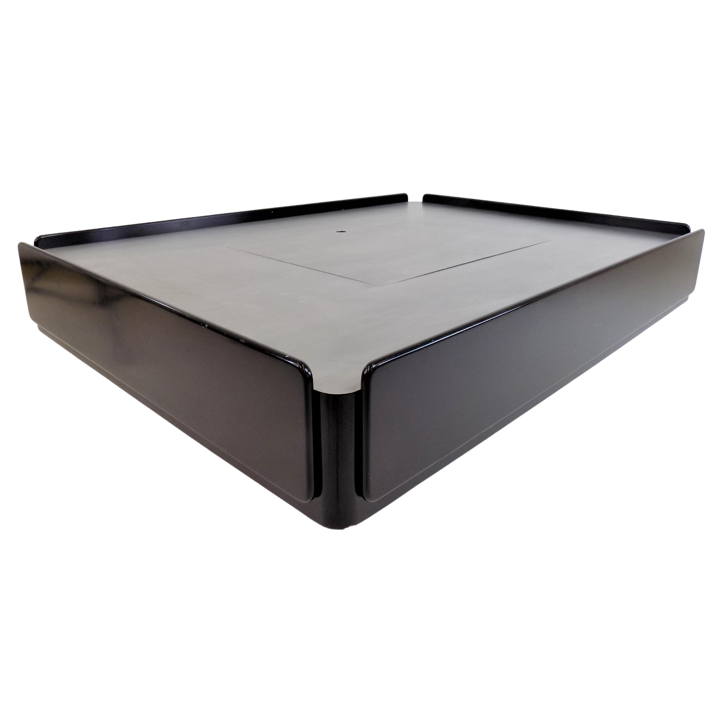 This black Caori coffee table is in very good condition. The black lacquered wooden elements show only slight signs of wear. The table top is made of satin stainless steel and is hidden under the flap in the middle of the table, which is held in