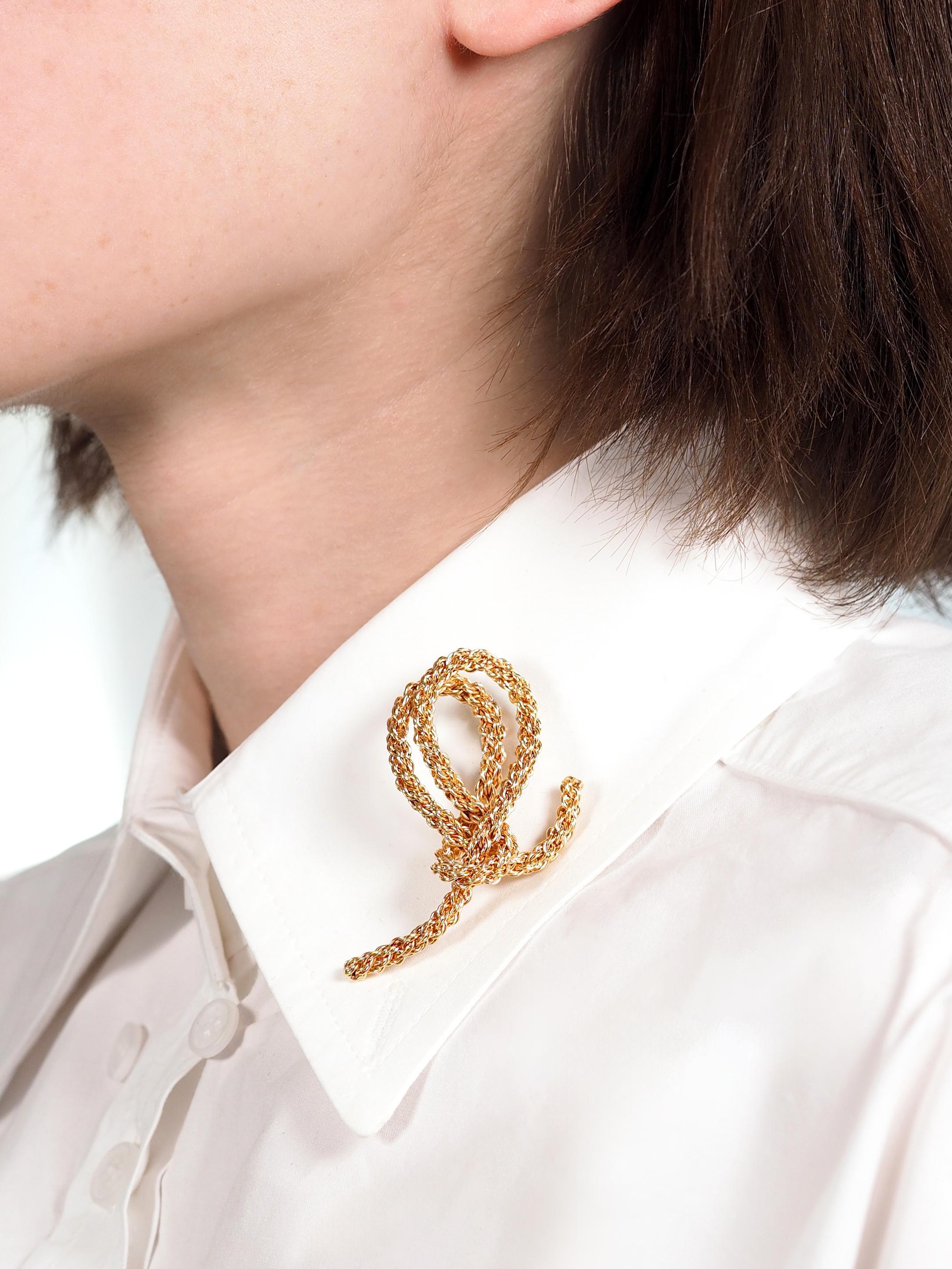 Designed as a double looped knot with flailing tails
Comprised of stiff meshed rope-like chain
With high polish finish
Completed by hinged pinstem with locking plunge closure
Stamped with French hallmarks for 18 karat gold
With maker's mark for Gay