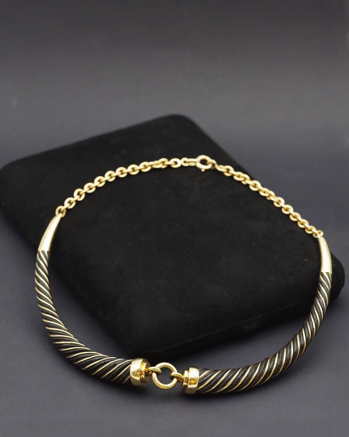 Collana Gay Freres torque in oro e argento 18 carati. Collana a coppia semi-articolata, composta da due elementi ritorti alternati in oro e materiale organico. I due elementi si incontrano al centro, trattenuti da un anello. La collana termina con