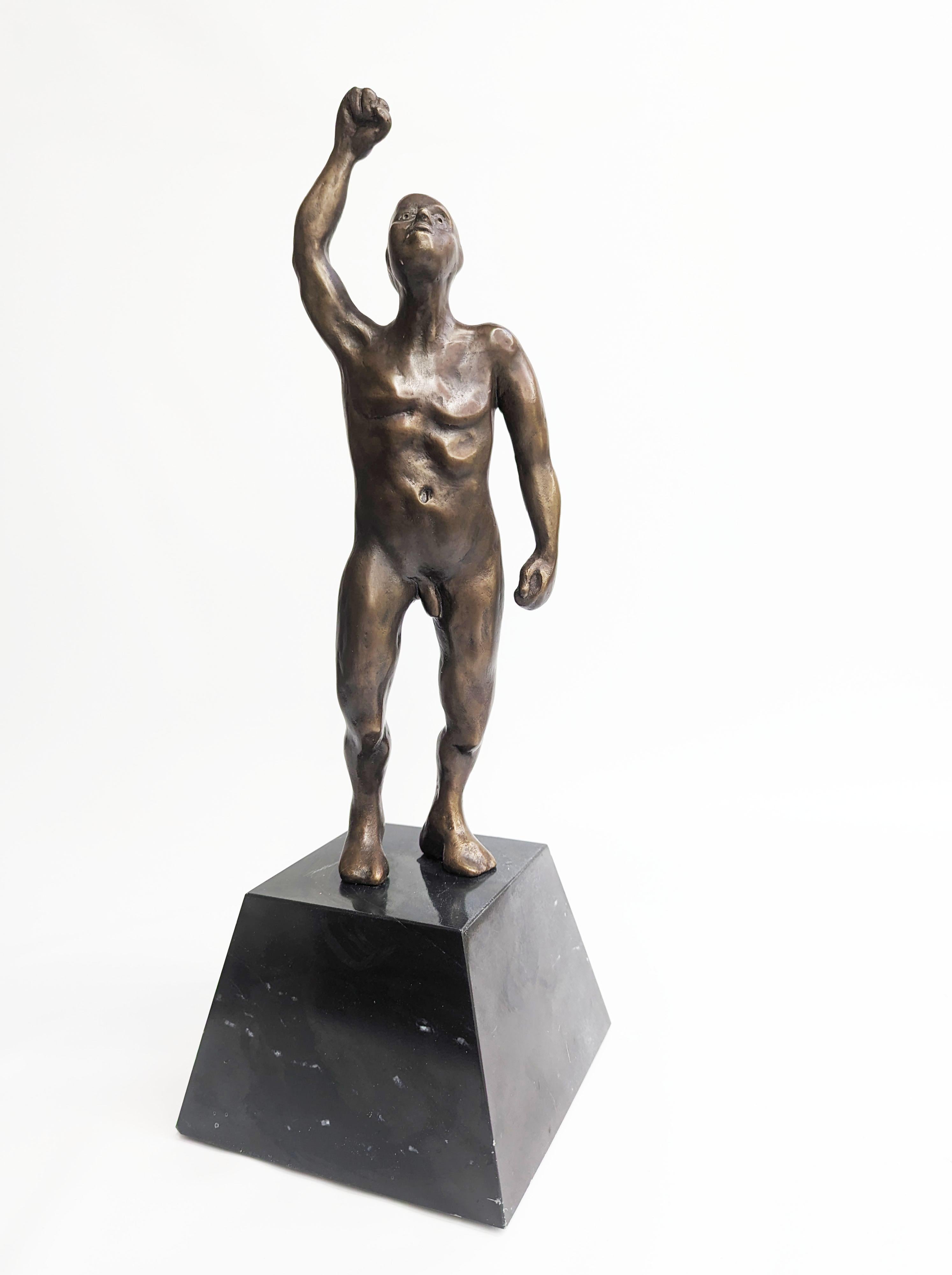 This bronze sculpture is a wonderful example of figurative work. On top of a marble base is a bronze nude figure . His body is muscular and athletic. He holds the right hand up in a fist as if celebrating a much worked for success. Titled 