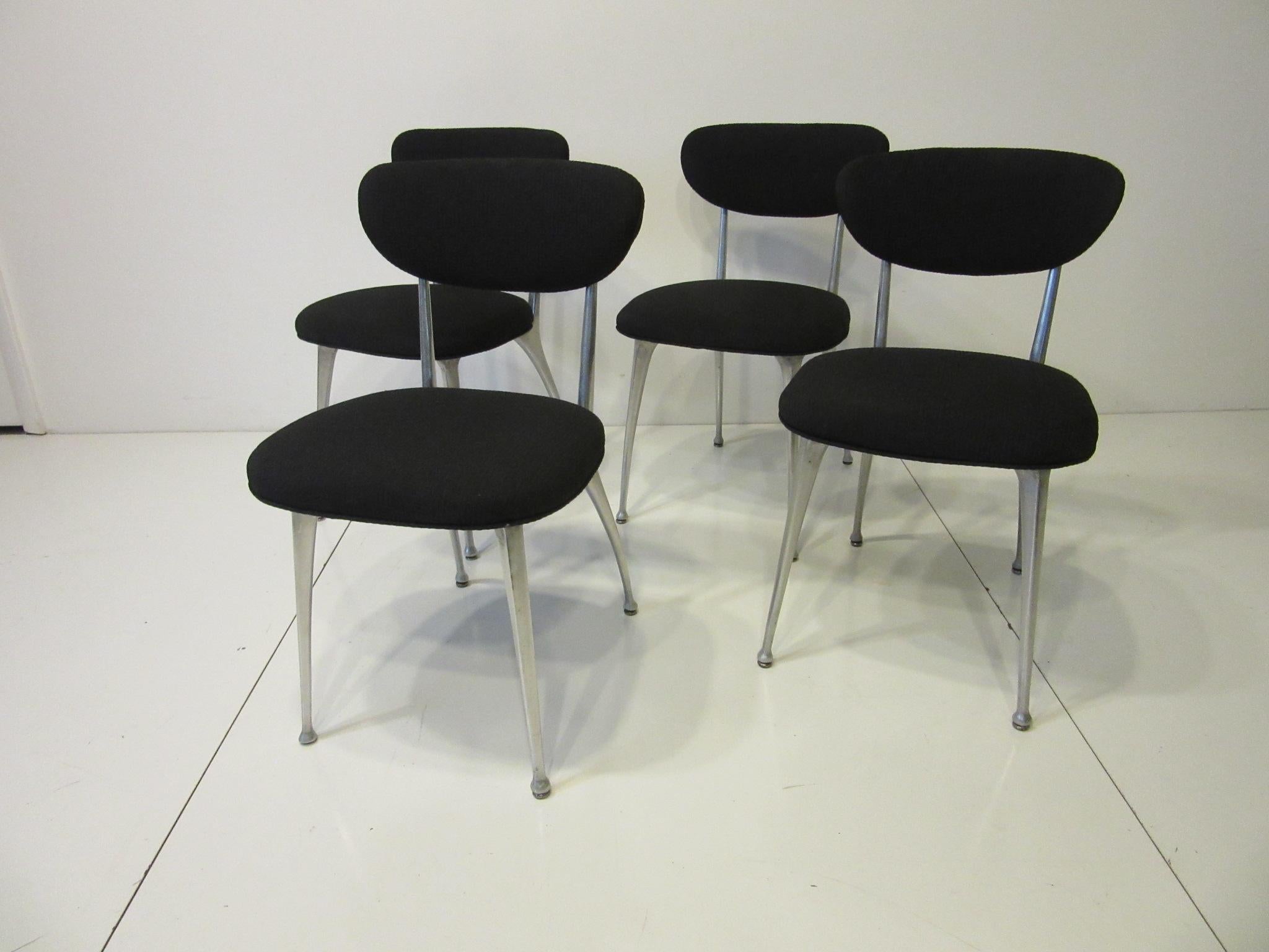 A set of four Gazelle chairs with cast aluminum frames and upholstered seats and backs with a textured black contract fabric. Called the Gazelle chair because of the strong but thin and light looking legs as in the African Gazelle, comfortable and