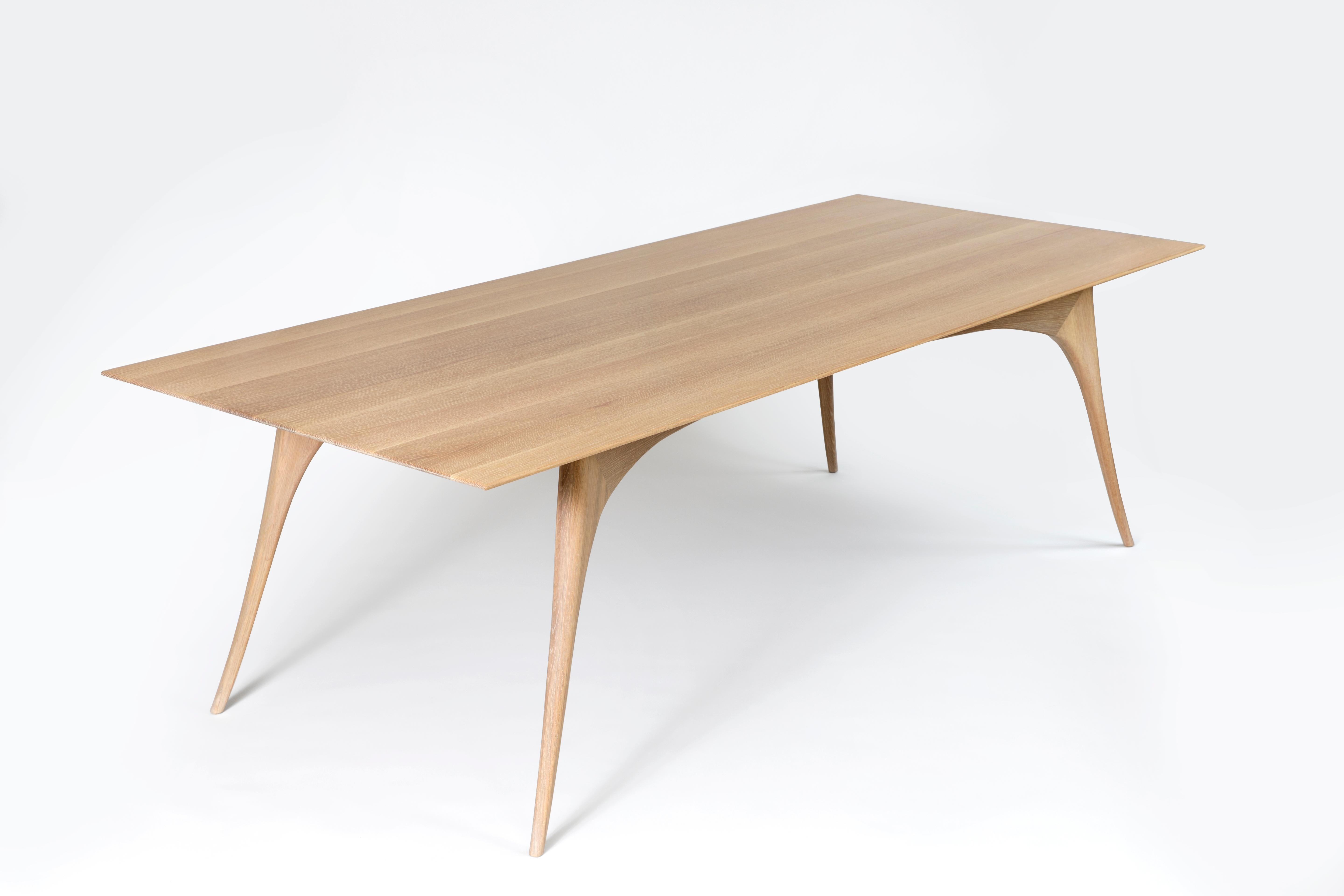 The Gazelle Dining Table in rift-cut white oak is featherlight in appearance, the whisper-thin wood surface floats atop graceful, curved legs that have been shaped by hand. The simplicity of this solid wood table's design belies its elaborate