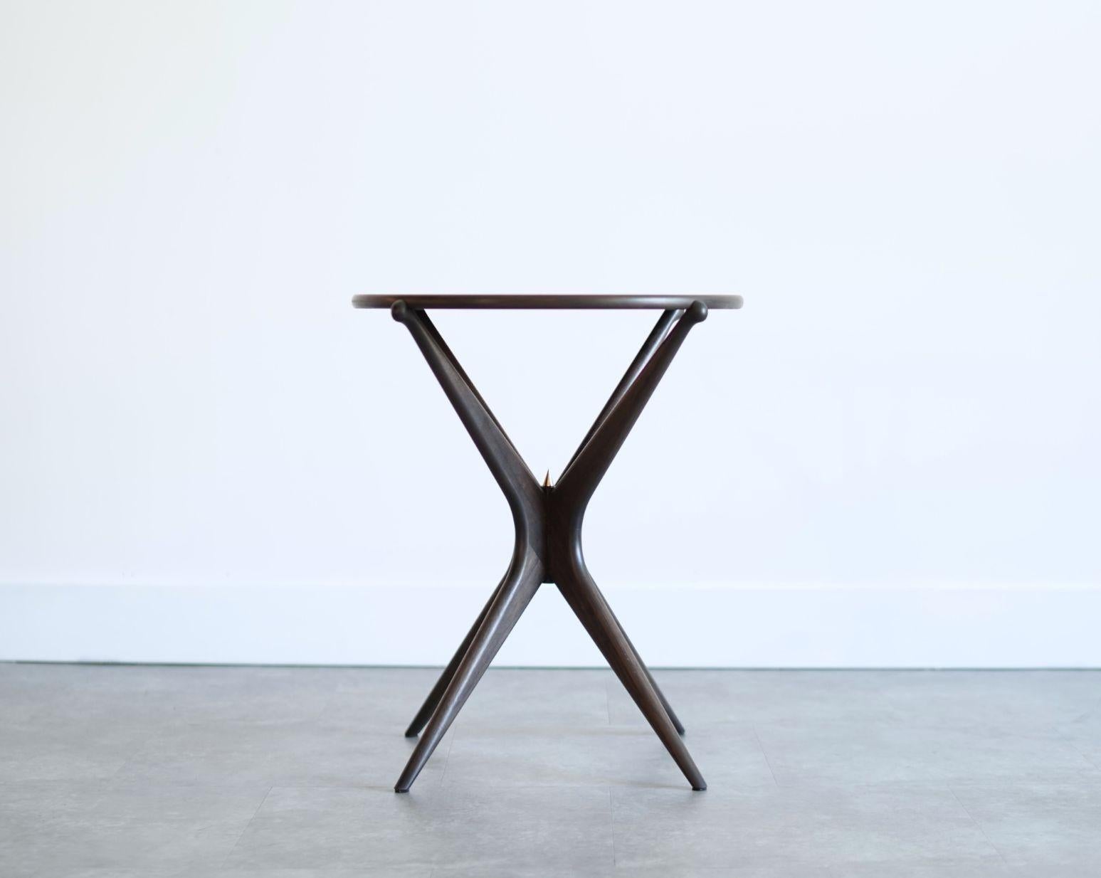 La table d'extrémité Gazelle Grande de Carlos Solano apporte une élégance sculpturale et un design moderne raffiné du milieu du siècle à n'importe quel espace. Fabriquée à la main dans le Connecticut, cette table d'appoint de luxe est fabriquée en