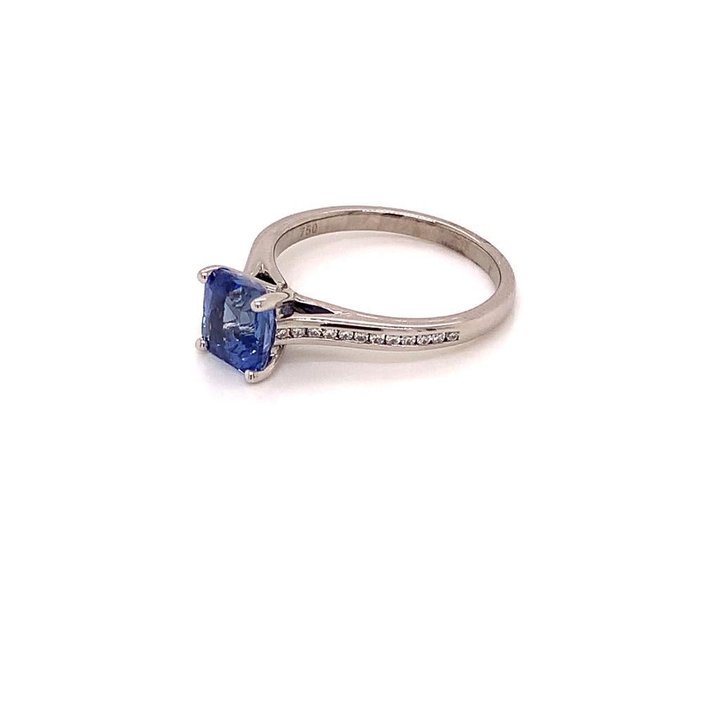 Made of a Spectacular Square Modified Blue Sapphire weighing 2.04 Carats and glittering Round Brilliant Diamonds weighing 0.16 Carats set in 18K White Gold, this ring is all about elegance. The Sapphire in this ring is unheated, making it a rare and