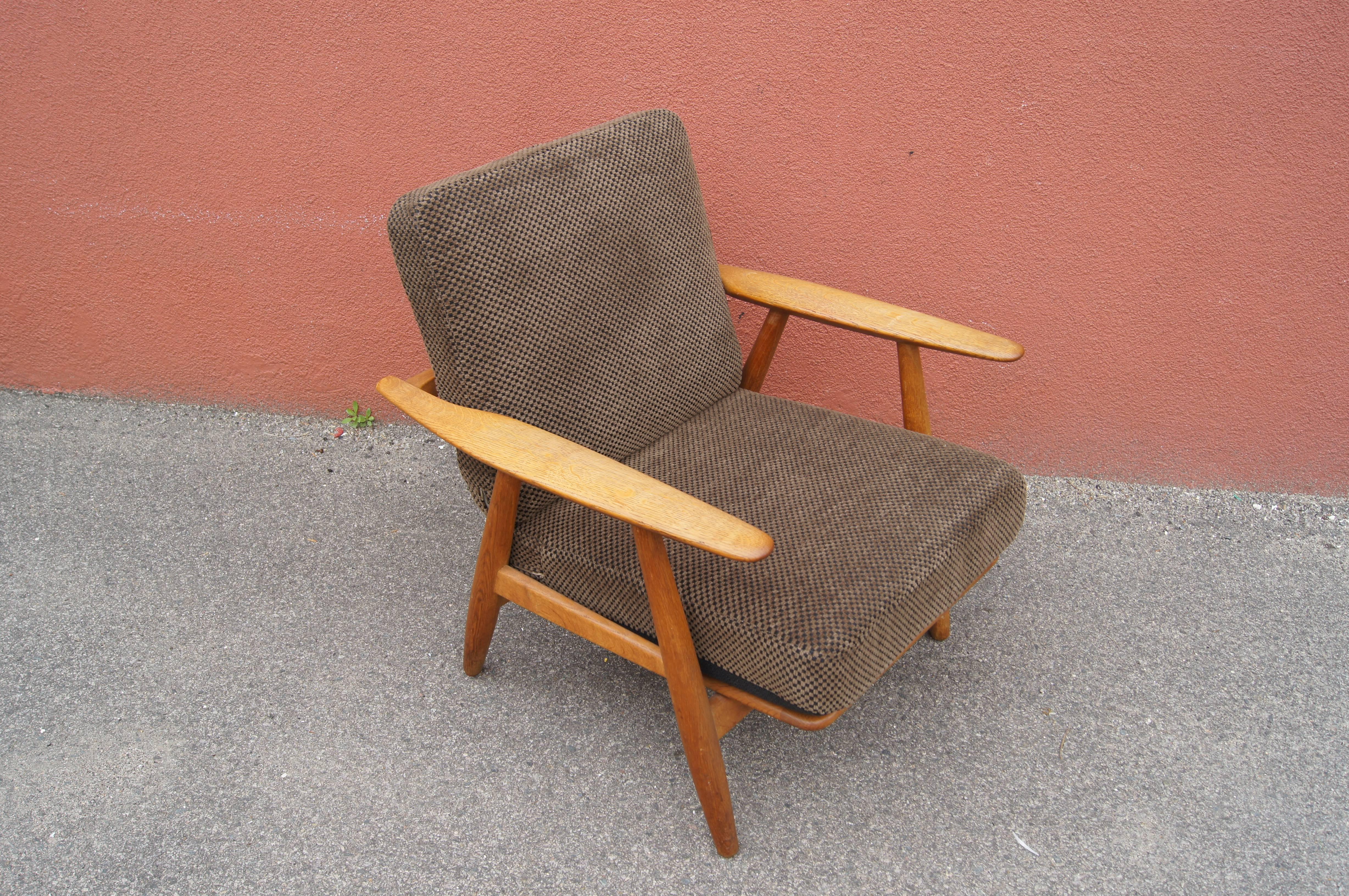 Hans Wegner designed this lounge chair, model GE240, for GETAMA in 1955. The gently curved armrests of the solid oak frame inspired its popular name: the cigar chair. It features the original spring cushions, upholstered in a soft bouclé with