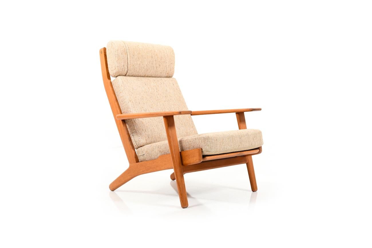 Highback lounge chair in solid teak. Model GE-290 by Hans J. Wegner. Manufactured by GETAMA. Original cushions in beige wool fabric.