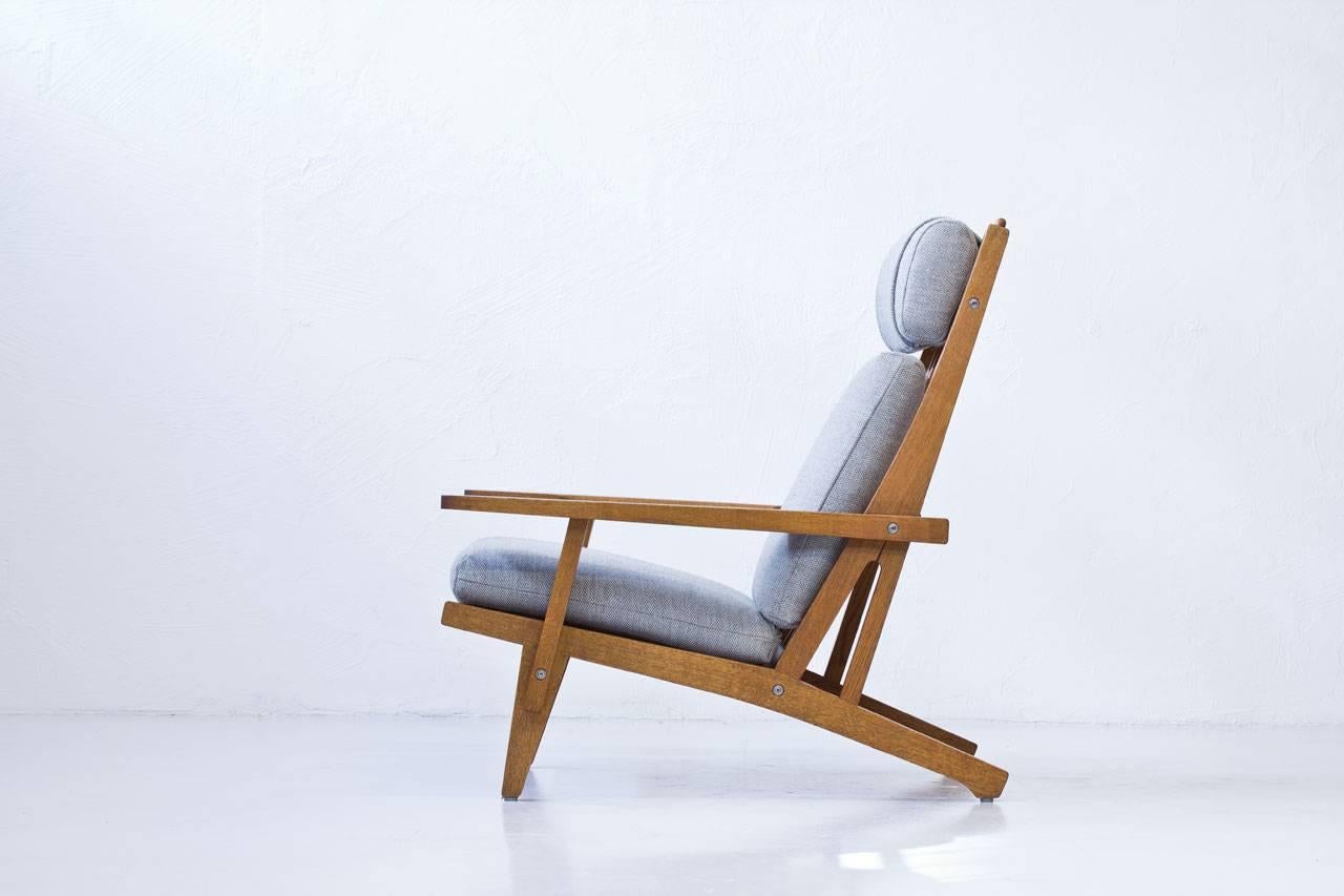 High back lounge chair model “GE- 375? designed by Hans J. Wegner. Produced by GETAMA, Gedsted in Denmark during the late 1960s. Solid oak frame with large removable armrests and adjustable neck pillow. Cushions newly upholstered with
wool fabric