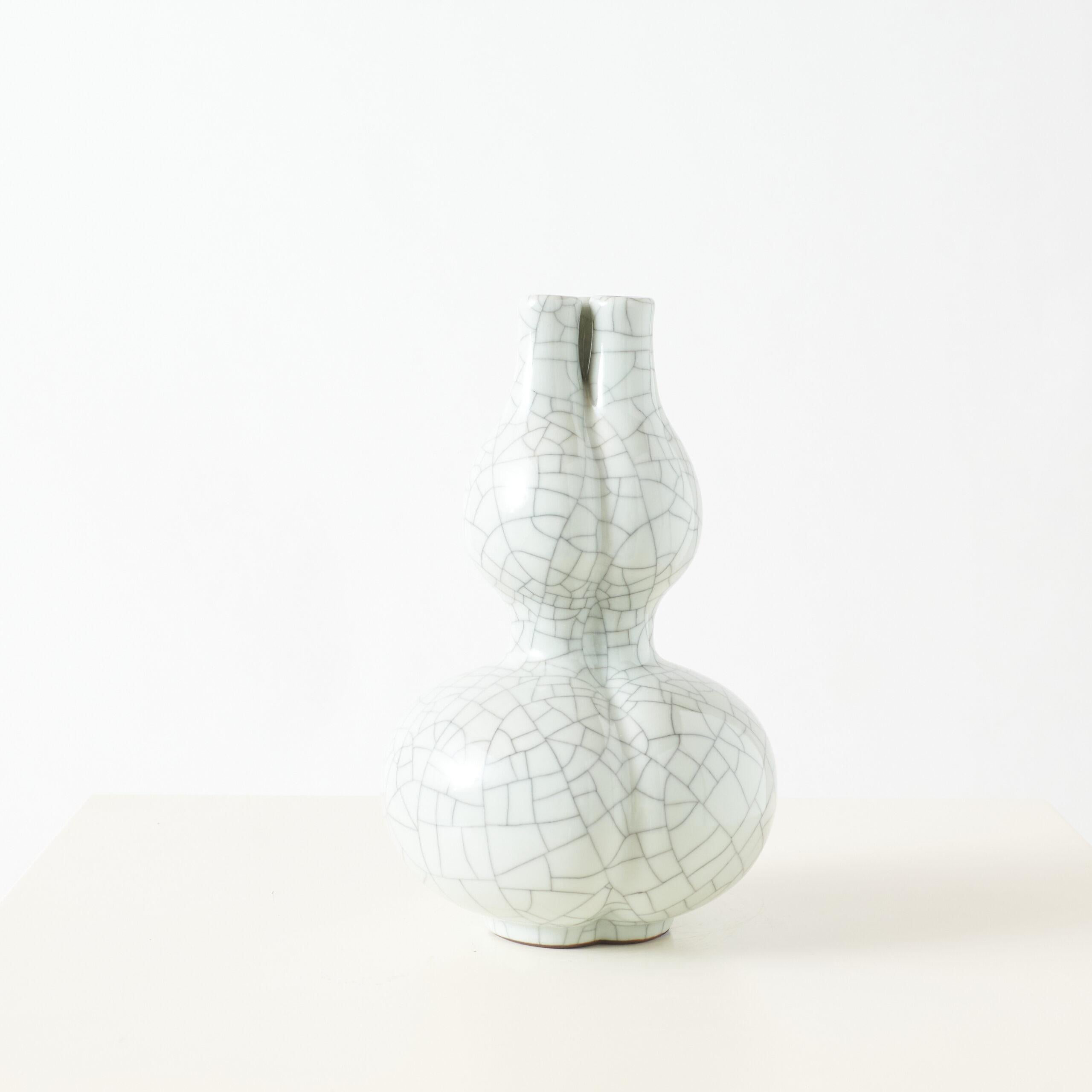 Glasierte Doppelkürbis-Vase mit drei Ausläufen

Diese chinesische Porzellanvase hat die Form einer Doppelkürbisschale mit einem charakteristischen dreifachen Ausguss. Sie ist mit einer fein craquelierten Ge-Glasur in einem weichen Seladon-Farbton