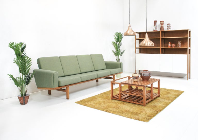 The model GE-236 / 4 sofa was designed by Hans J. Wegner in 1955 for Getama Denmark. 

It features a solid oak frame and loose cushions in green cotton fabric.