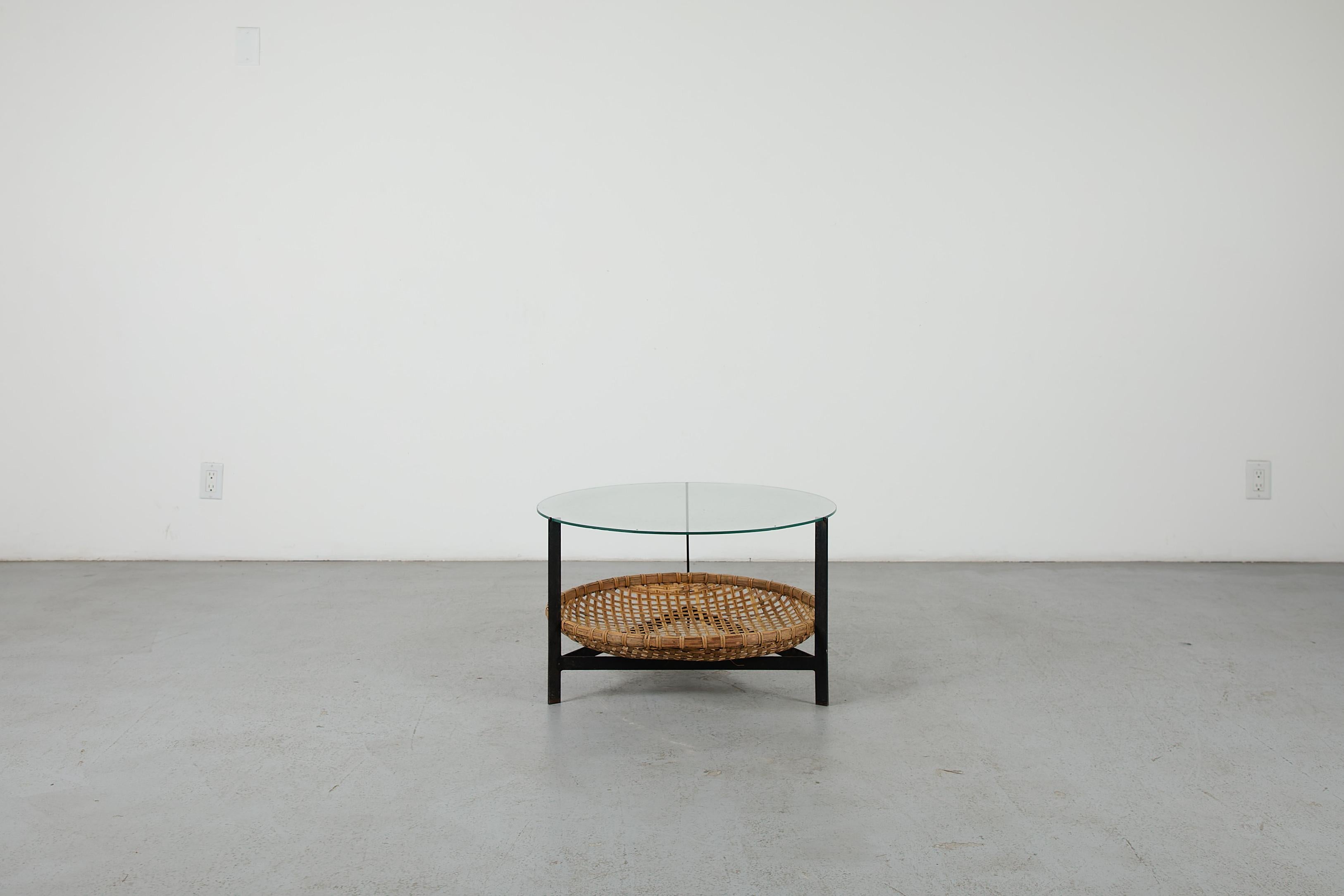 Table basse moderniste hollandaise du milieu du siècle, avec une belle structure en métal émaillé noir, un panier en forme de bol tressé à la main et un plateau en verre. Le design est attribué à l'illustre Gebr. Jonkers et date de la première