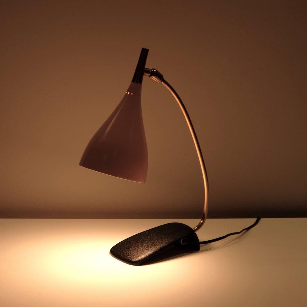 Designed by Stürzenhofecker and Becker for Gebrüder Cosack. Manufactured in the 1950’s for Gebrüder Cosack. Pink enameled pierced aluminium shade, brass swivel and stem on black enameled steel foot. Candelabra incandescent G-16.5 bulb 60 watts max