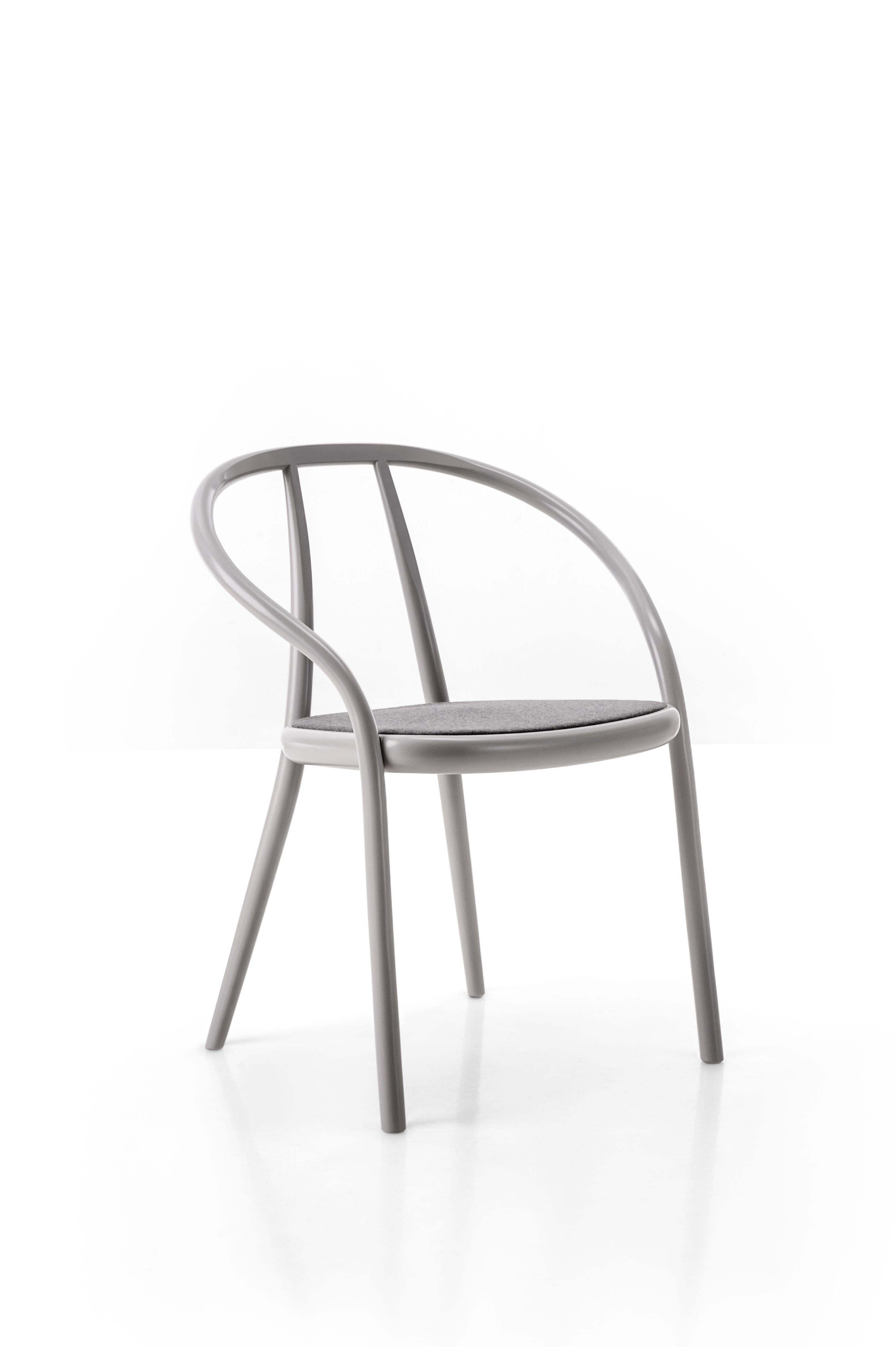 Gustav by Gordon Guillaumier has a solid beech structure with its backrest and arm rests joined to the front legs by a single curved element with a round section. The back legs are connected to the backrest, pandering to its natural curves and