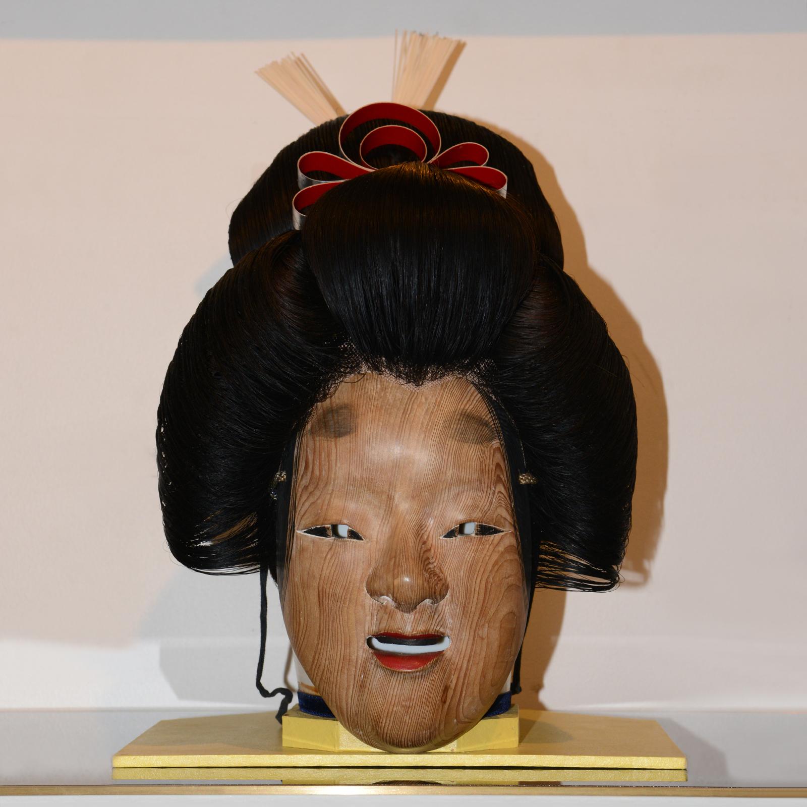 Maske Geisha Perücke & Nô Theater 2, mit echtem Naturhaar Geisha Perücke
auf Kopfmodell und mit Nô Theater Naturholzmaske.
Sockel: 28,5x26,3cm.