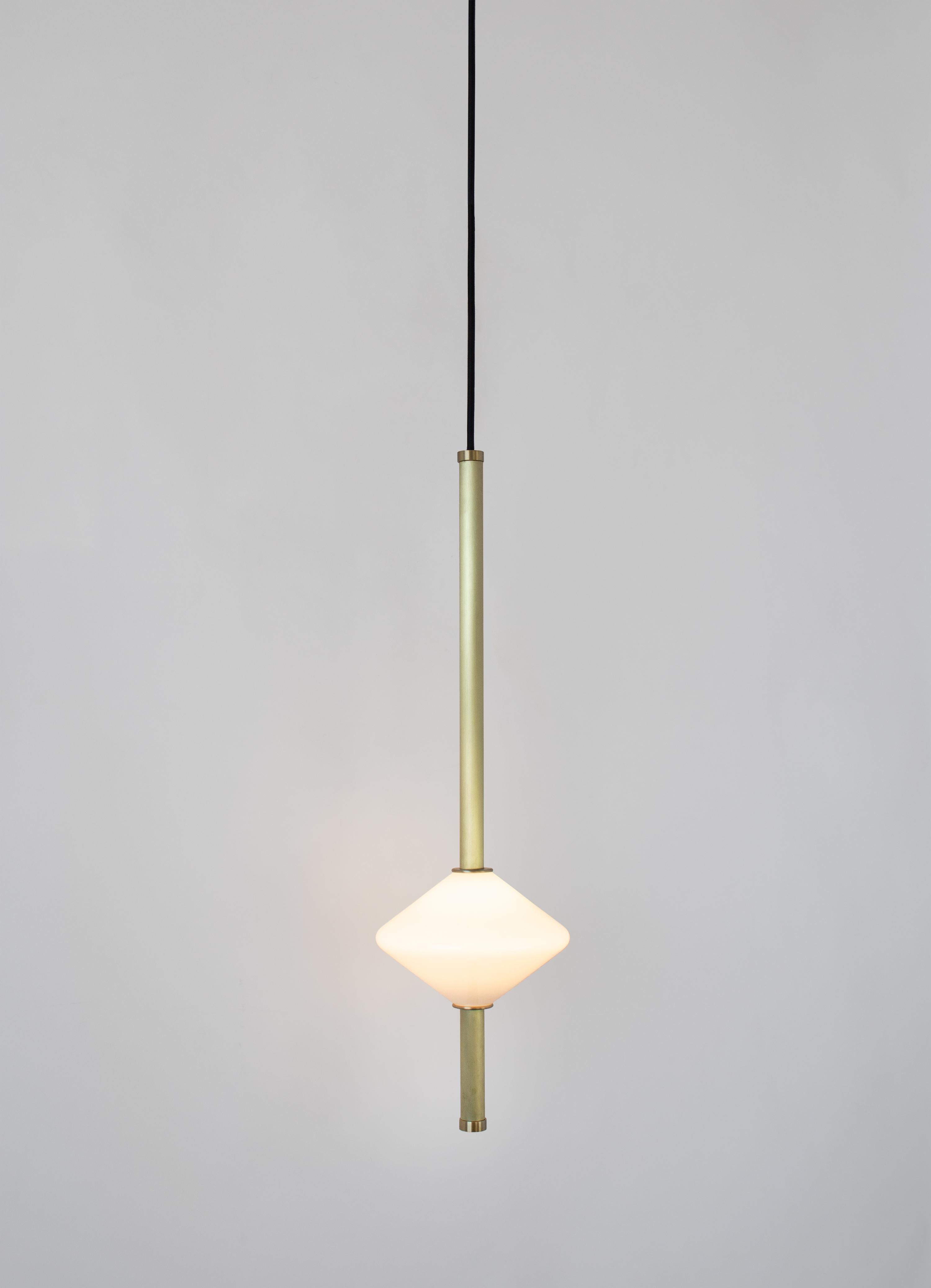The GEM 1 Vertical Pendant is built of brass with an LED light source that is diffused by a hand-blown opal white glass diffuser. Each pendant is suspended from a black cord set with 5 inch diameter canopy. This pendant works as an individual