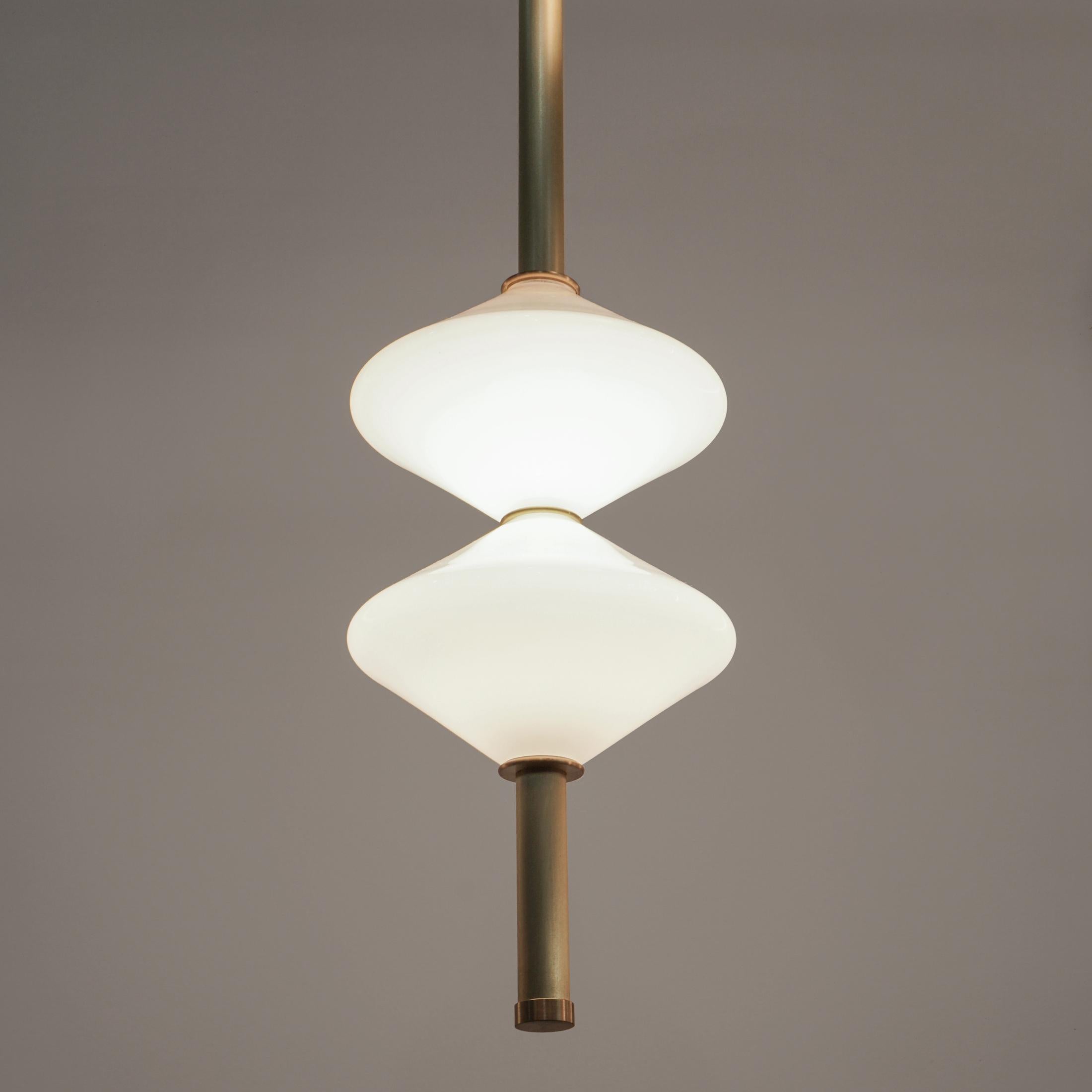The GEM 2 Vertical Pendant is built of brass with an LED light source that is diffused by a hand-blown opal white glass diffuser. This pendant works as an individual fixture or can be installed in larger groupings to create a dynamic installation.