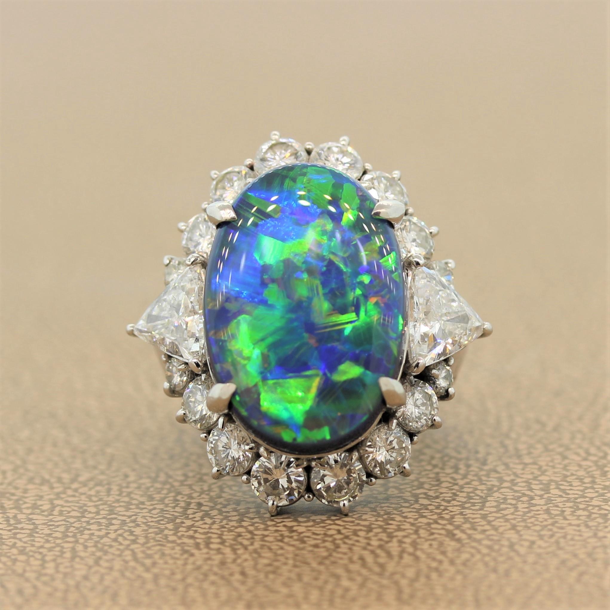 This tremendous ring is the first and last cocktail ring you will ever want to own. A remarkable 12.28 carat black opal surrounded by 4.16 carats of round cut diamonds and a trillion cut diamond at each shoulder. The black opal shows large and
