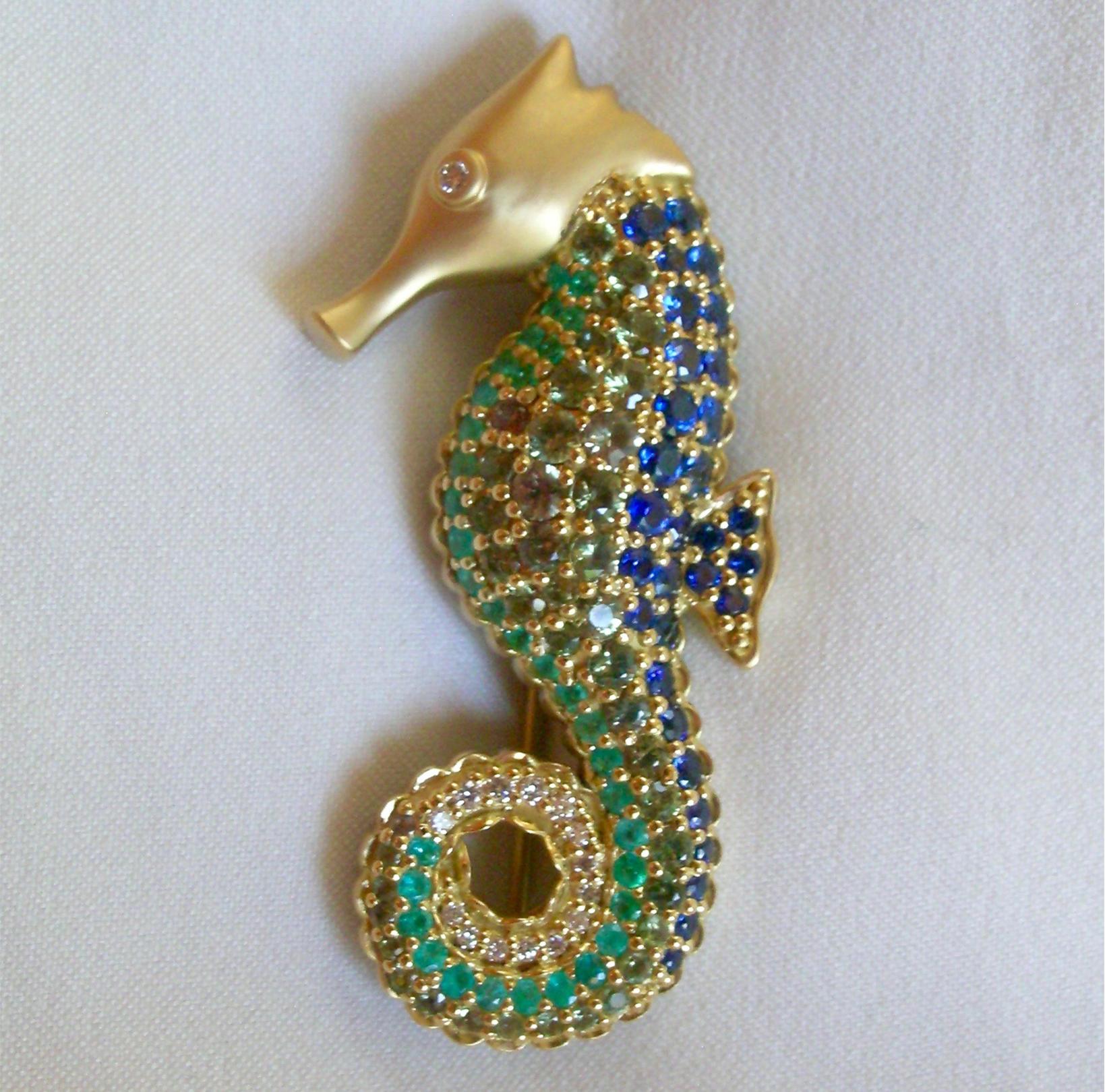 Anyone looking for an amazing, unique and absolutely gorgeous brooch or lapel pin, look no further.  This work of art has over 7 carats of Blue & Green Sapphires, Emeralds and Diamonds.  Pictures are worth a thousand words, so look closely at the