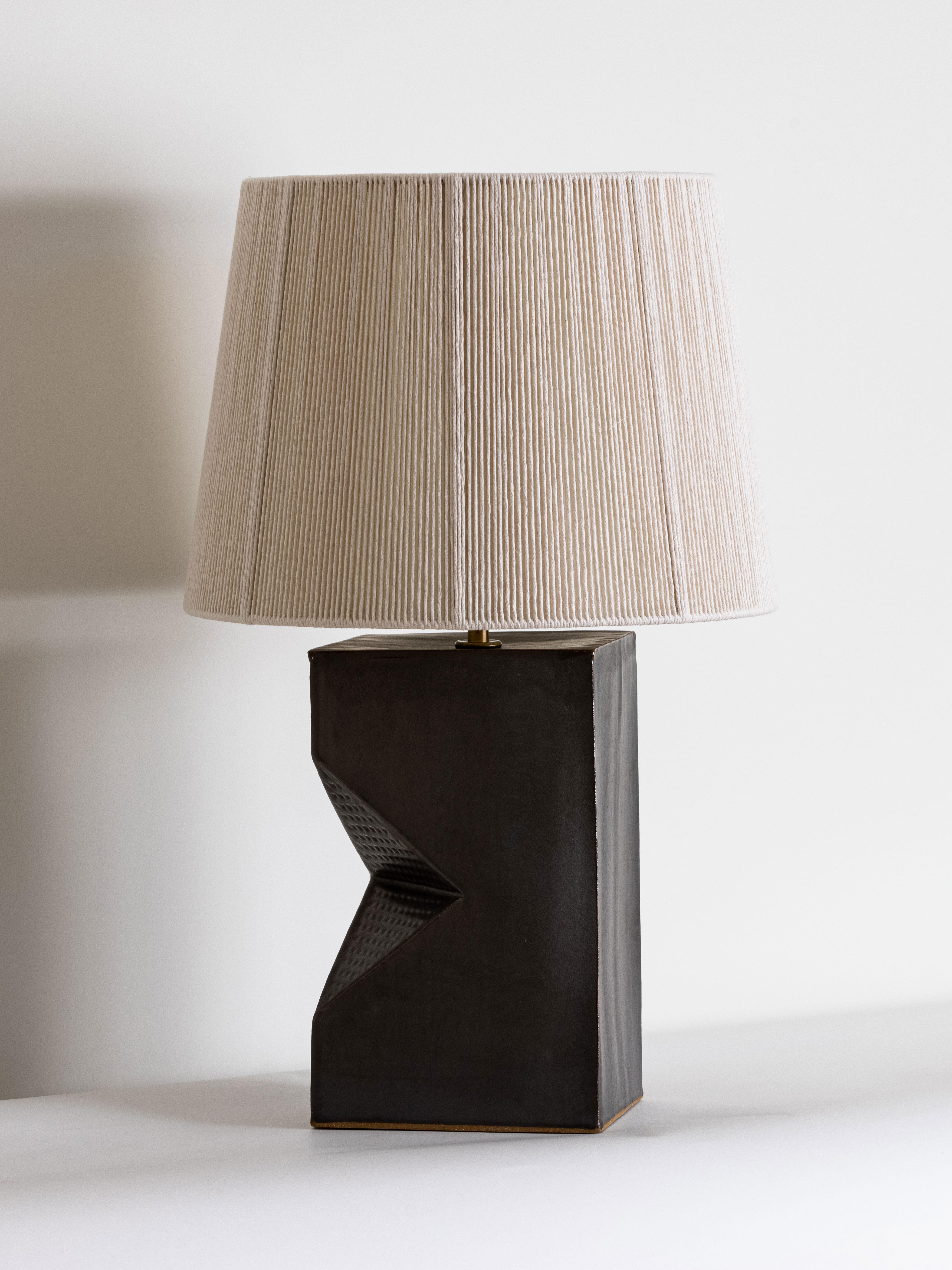 Our stoneware Gem Lamp is
handcrafted using slab-construction
techniques. The lamp’s pattern is created by rolling the surface with textured rolling pins and rods.

FINISH

- Dipped glaze, pictured in walnut 
- Antique brass fittings
-