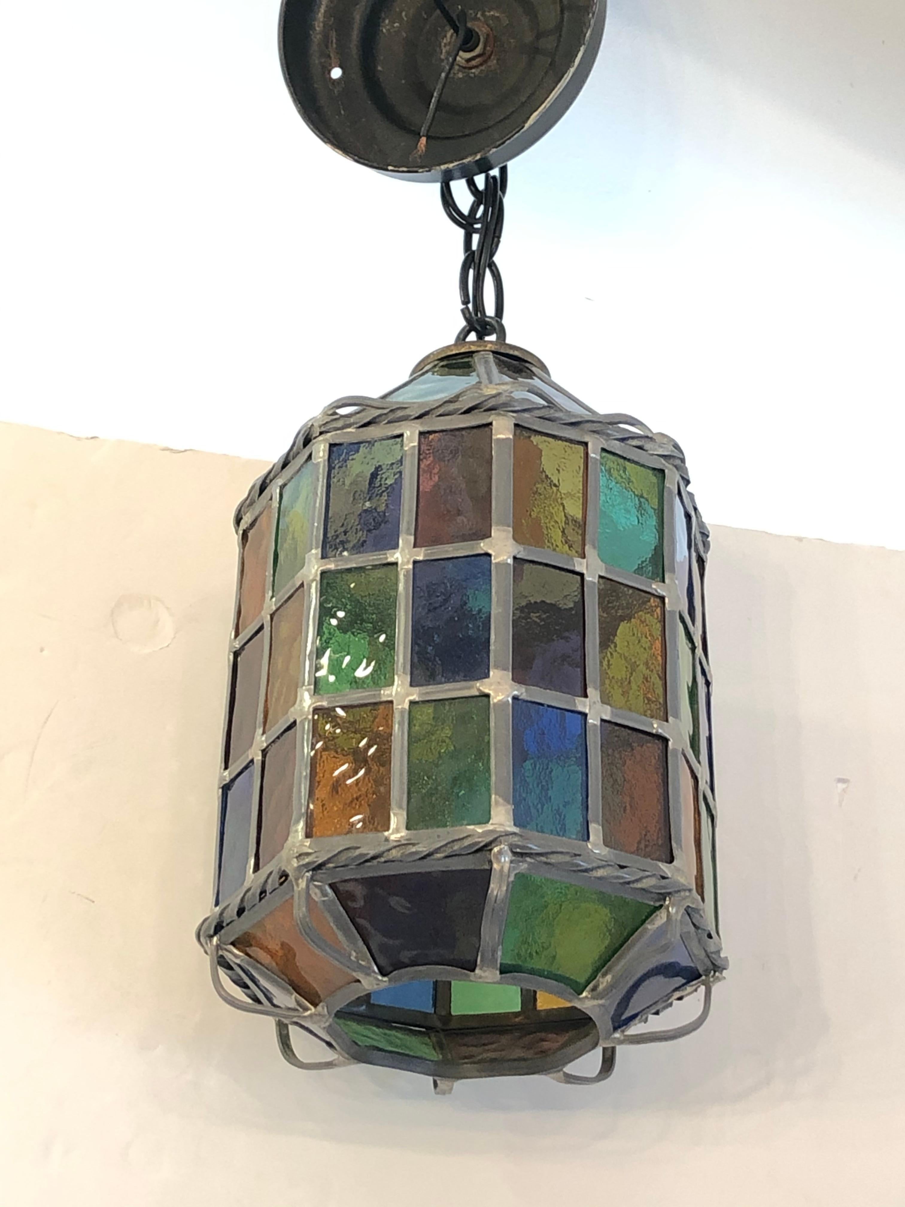 A magical small octagonal multi colored stained glass pendant lantern having single socket, canopy and about 6