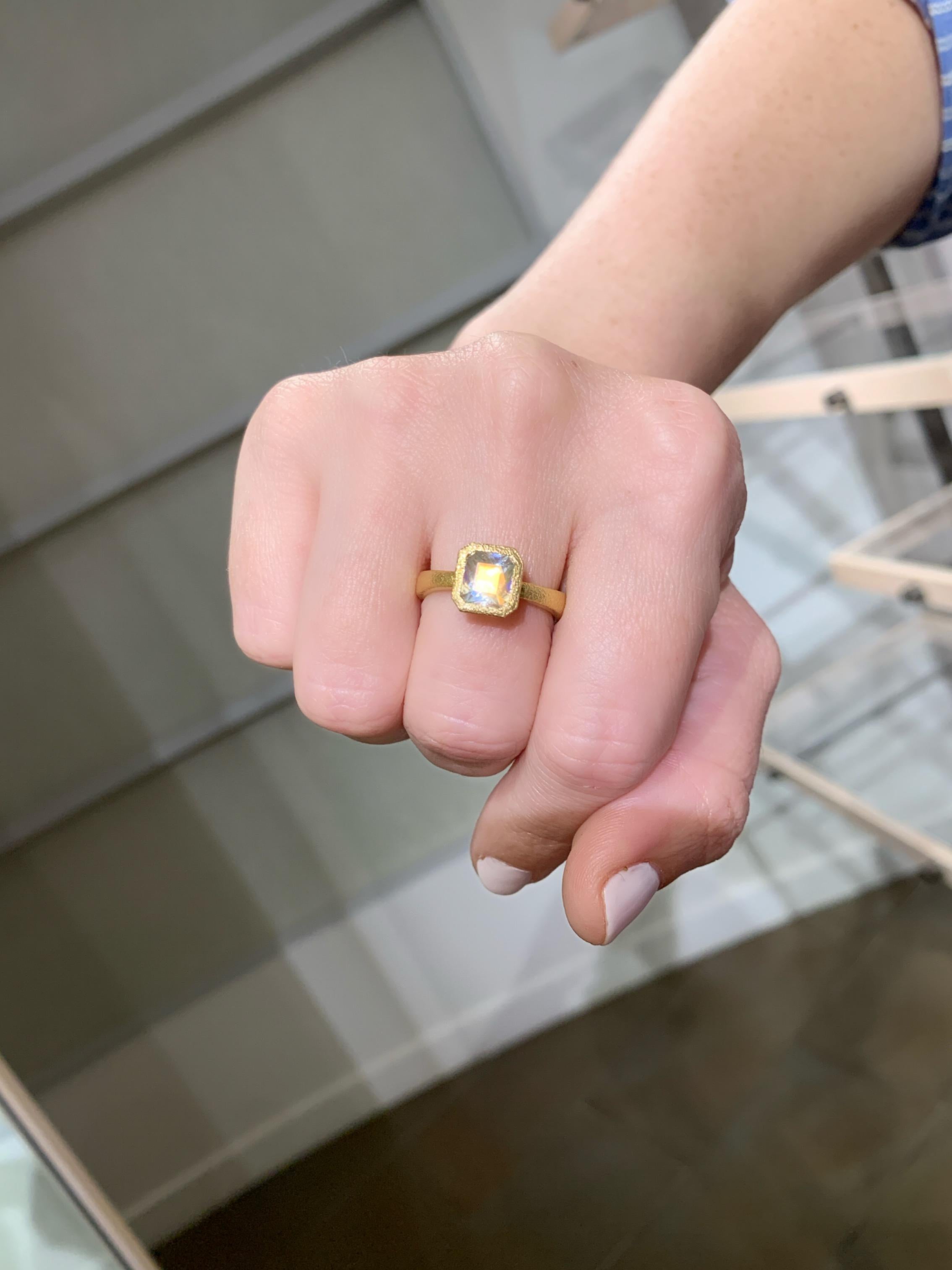 Einzigartiger Ring, handgefertigt vom renommierten Schmuckhersteller Devta Doolan aus fein strukturiertem 18-karätigem Gelbgold mit einem außergewöhnlich feinen, orangefarbenen Regenbogen-Mondstein, der mit spektakulärer Regenbogen-Adulareszenz und