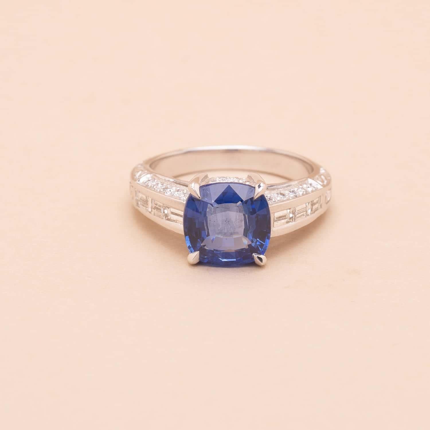 3.37 carat cushion-cut sapphire, round and baguette-cut diamonds ring. 
Gem Paris certified sapphire 
Estimated weight of the diamonds : 0.80 carat total 
Estimated characteristics : color F, purity VS
Art Deco style but contemporary made. Perfect