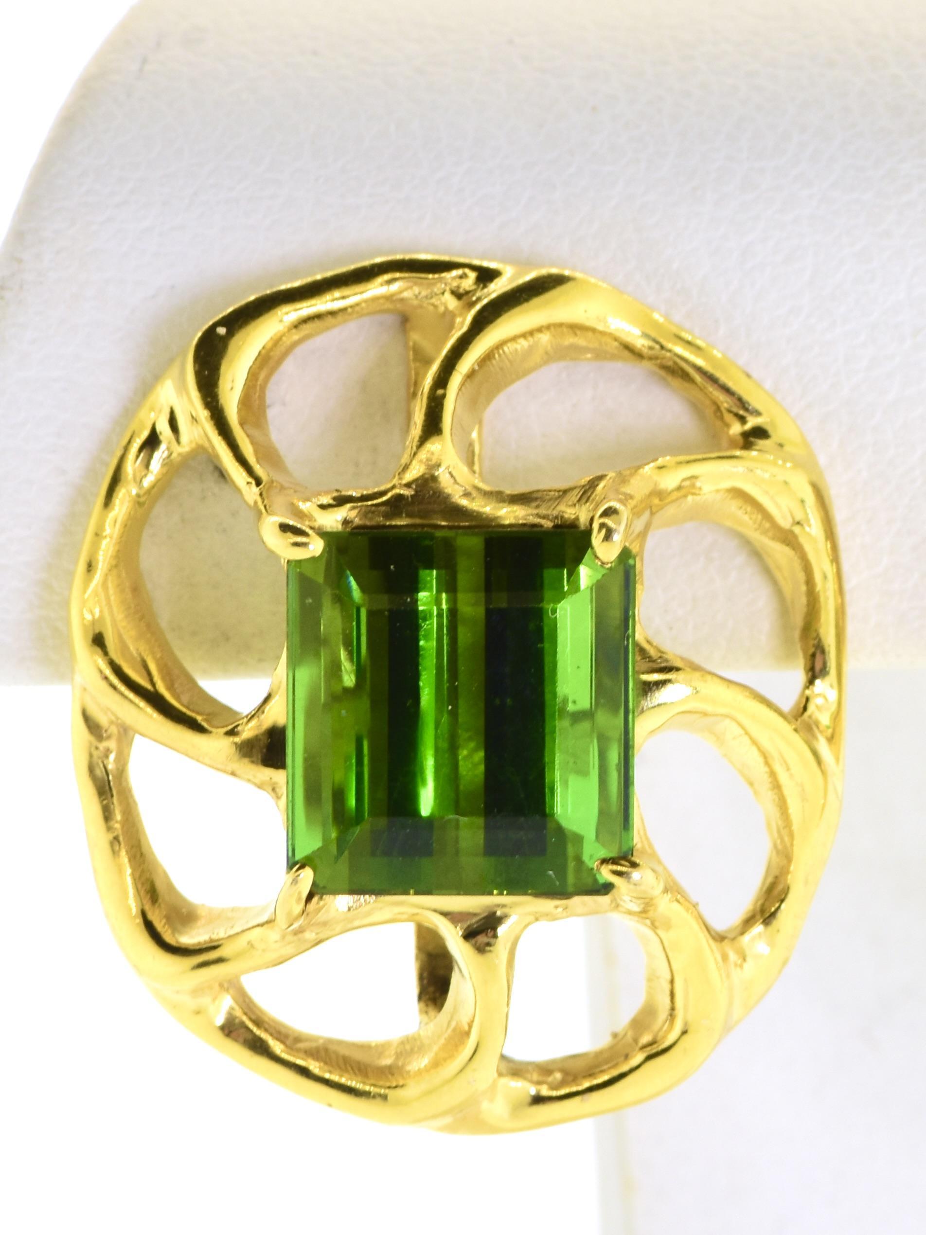 Yellow gold clip-on earrings with a contemporary design. These earrings feature a striking square-cut green tourmaline as the central element. The gold is crafted into a modern open, swirling pattern that elegantly frames the stone. Each earring is