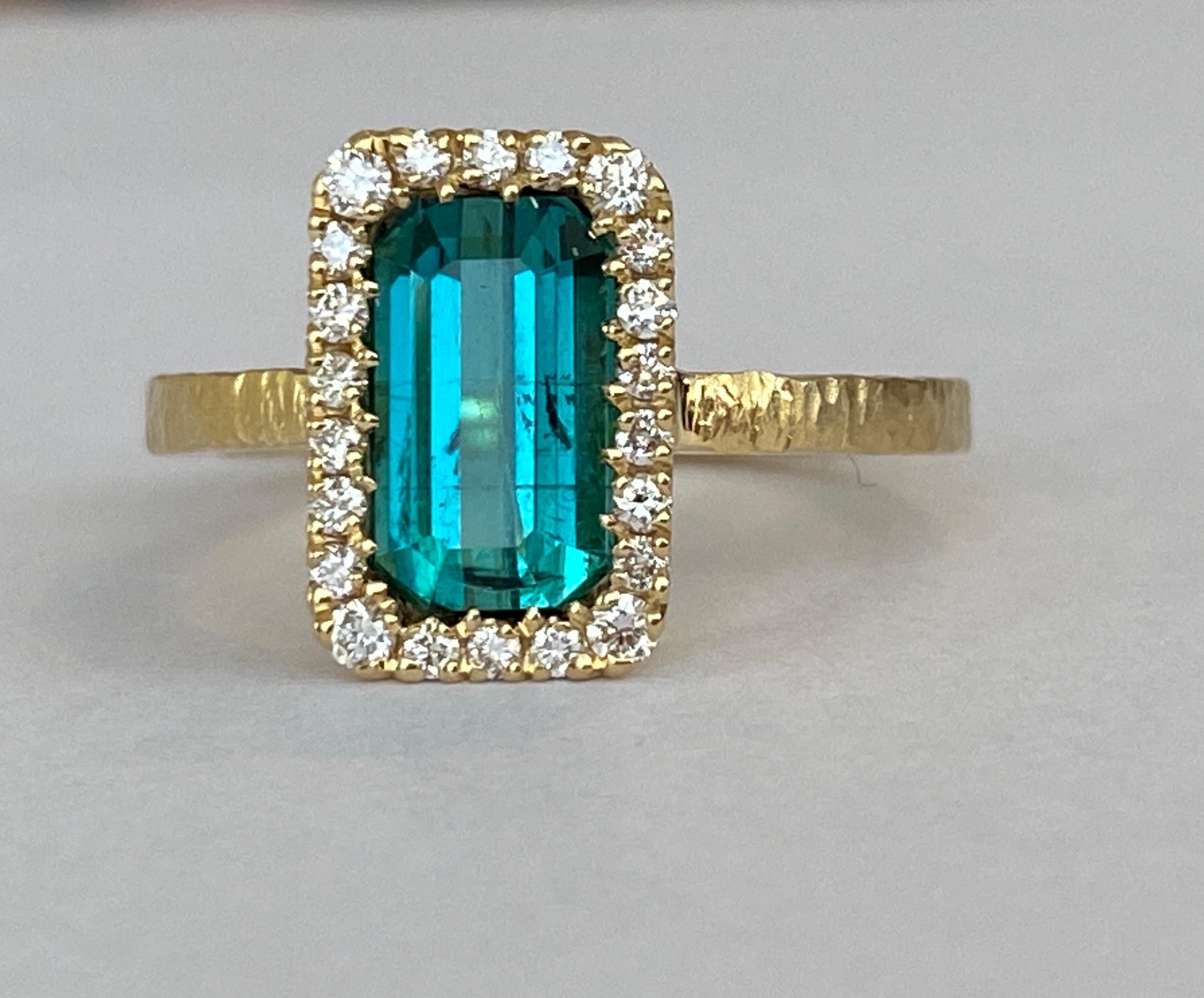 Esclusivo anello fatto a mano in oro giallo martellato 18 kt con incastonatura di  tormalina lagunare taglio smeraldo di 2,35 carati e decorata con 22 diamanti taglio brillante. Totale diamanti: 0,15 ct F/G/VS. Il certificato GEM Report Antwerp è