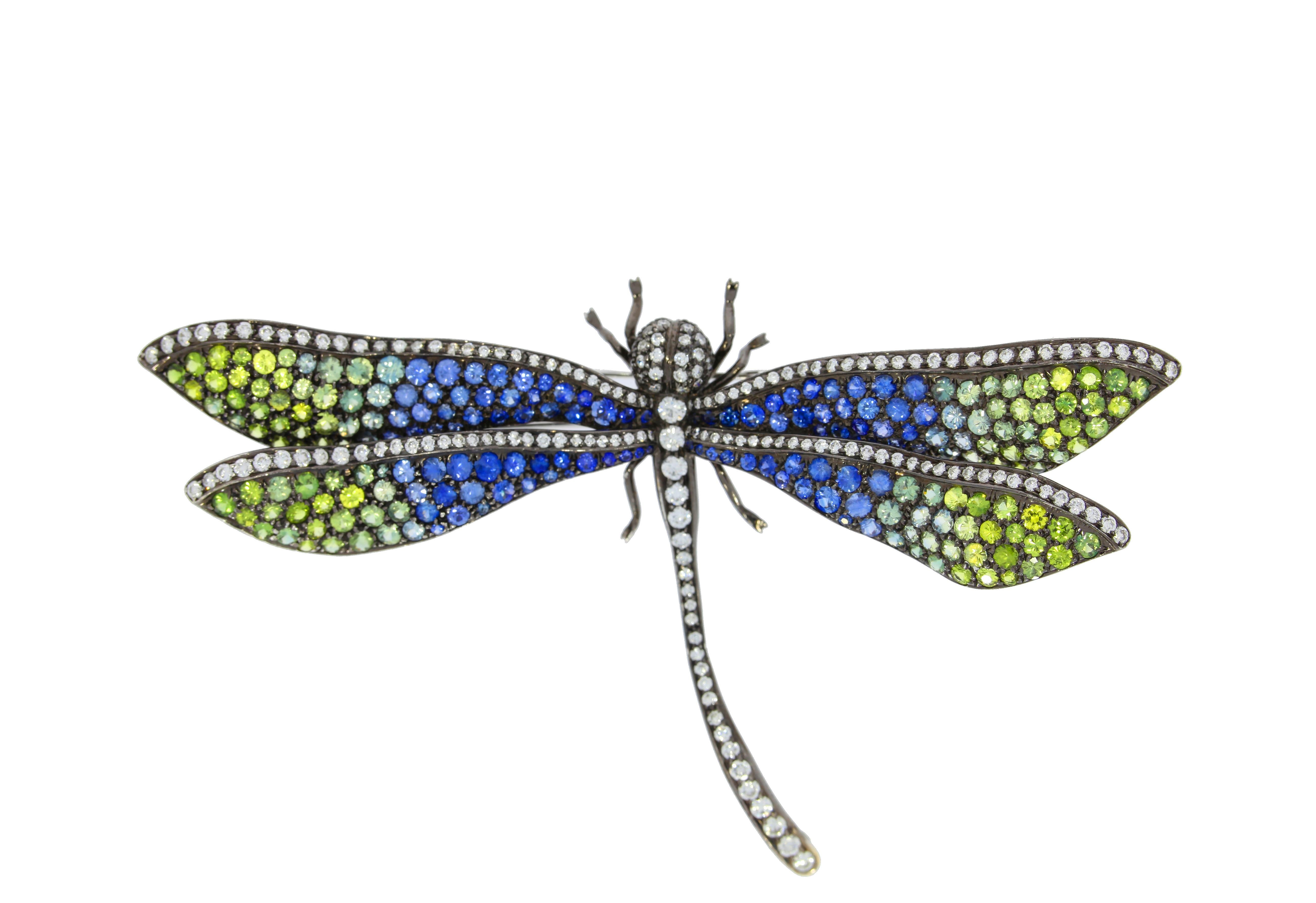 This delightful gemstone brooch in the form of a dragonfly, is beautifully decorated with multicolored sapphires on the wings. The head and tail are enhanced with a row of sparkling white diamonds. Will add conversation-starting style to any outfit.
