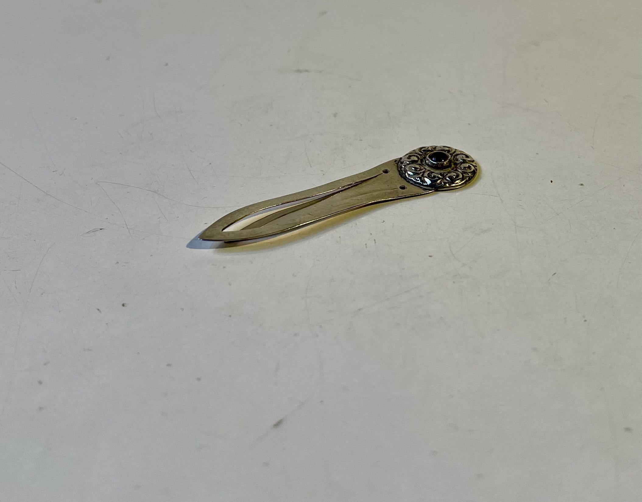 Wilhelm Volck, un rinomato argentiere di Copenaghen, ha realizzato questo piccolo e pratico segnalibro di lusso in argento 830/1000. Dettagli finemente incisi e ornati da una piccola gemma rossa centrale. Realizzato in Danimarca intorno al 1920-29.
