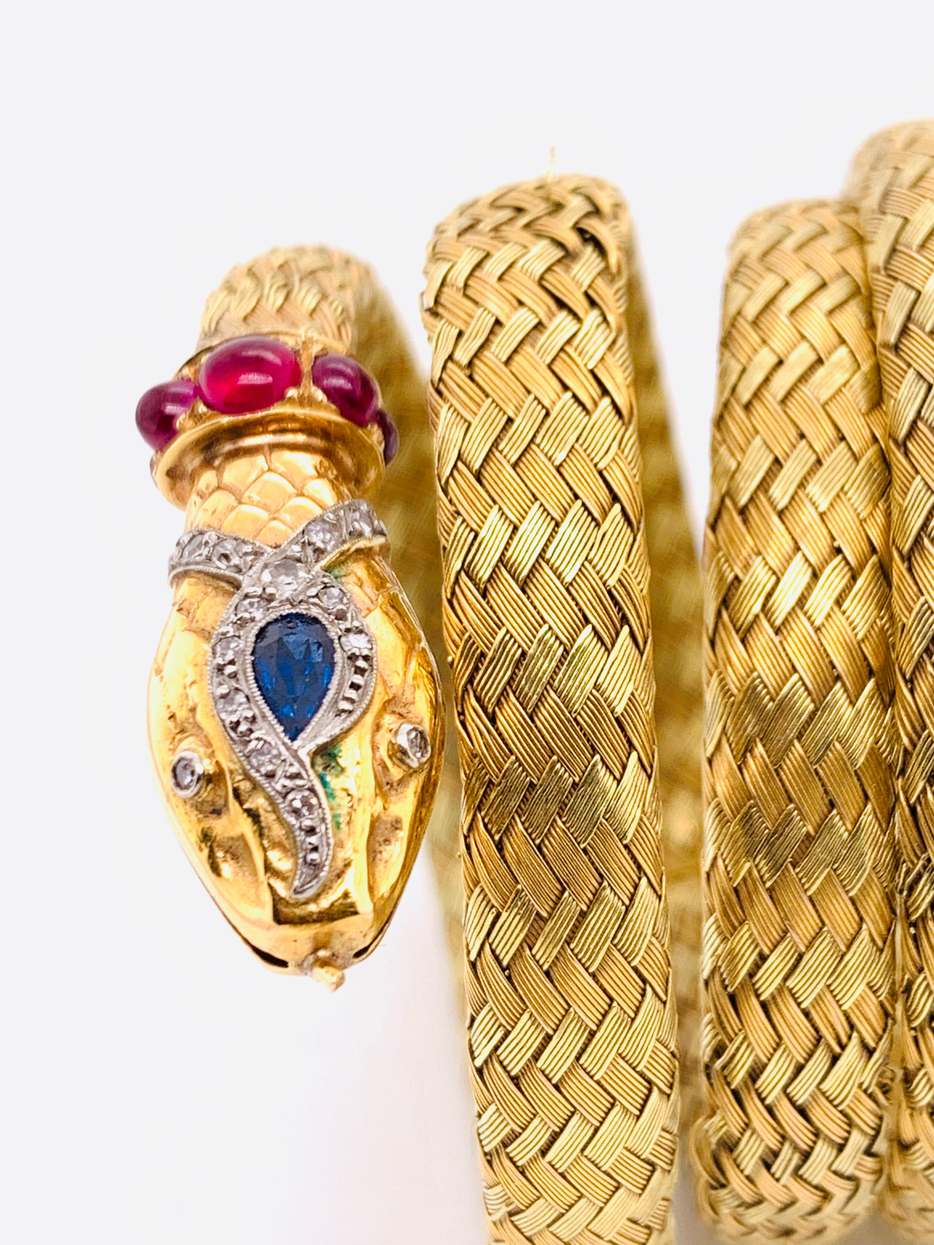 An antique French, yellow and red woven gold, snake bracelet, with eight-cut diamonds and a pear shape sapphire set in the head with cabochon-cut rubies around the neck. With a French eagle mark and numbered 6 or 9 maker's mark, circa 1880.