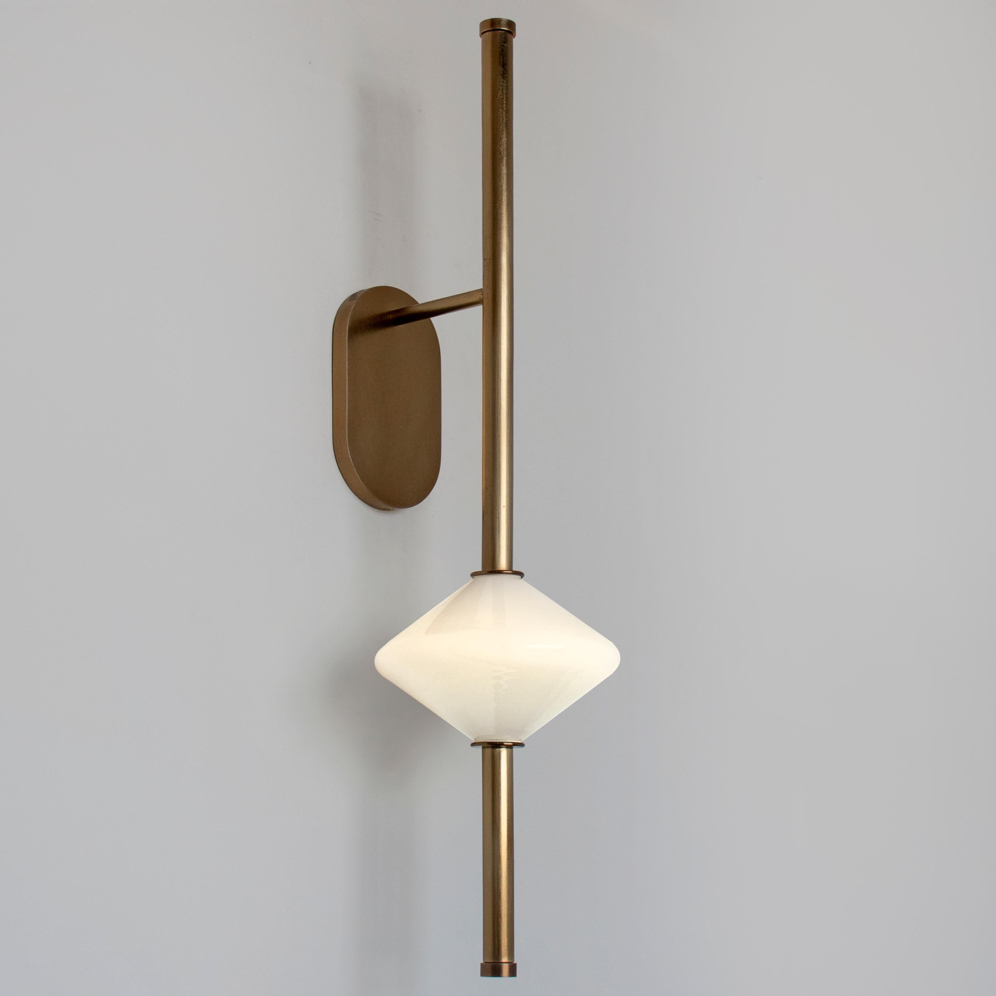 The GEM1 Wall Sconce is built of steel with an LED light source that is diffused by a hand-blown glass diffuser inspired by the shape of an abacus bead. This variation on the Gem Sconce features a fixed positioned arm, making it suitable for high