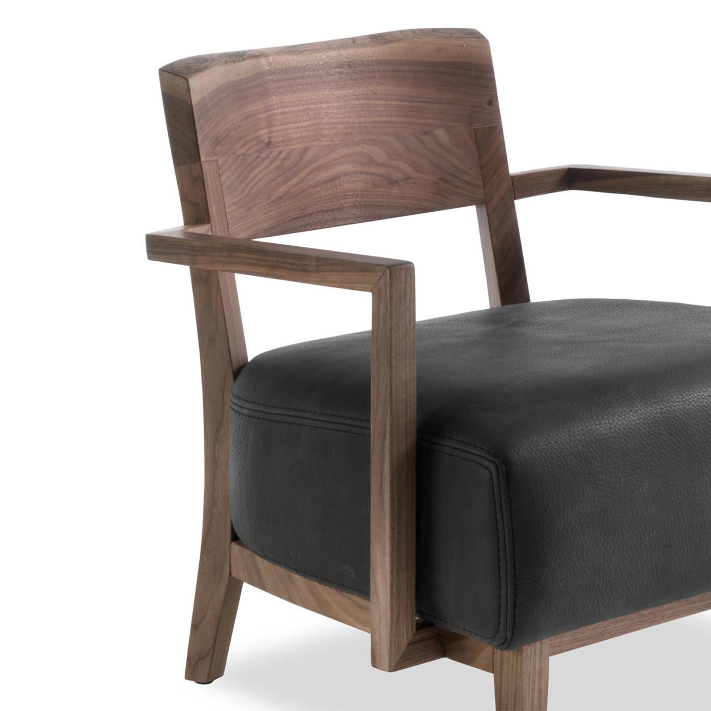 Poltrona Gemini con struttura in legno massiccio di noce,
trattati con estratti naturali di pino. Sedile imbottito
e rivestito in vera pelle naturale di alta qualità
(Cat; D4) con finitura nera. Disponibile anche con altri colori di pelle
su
