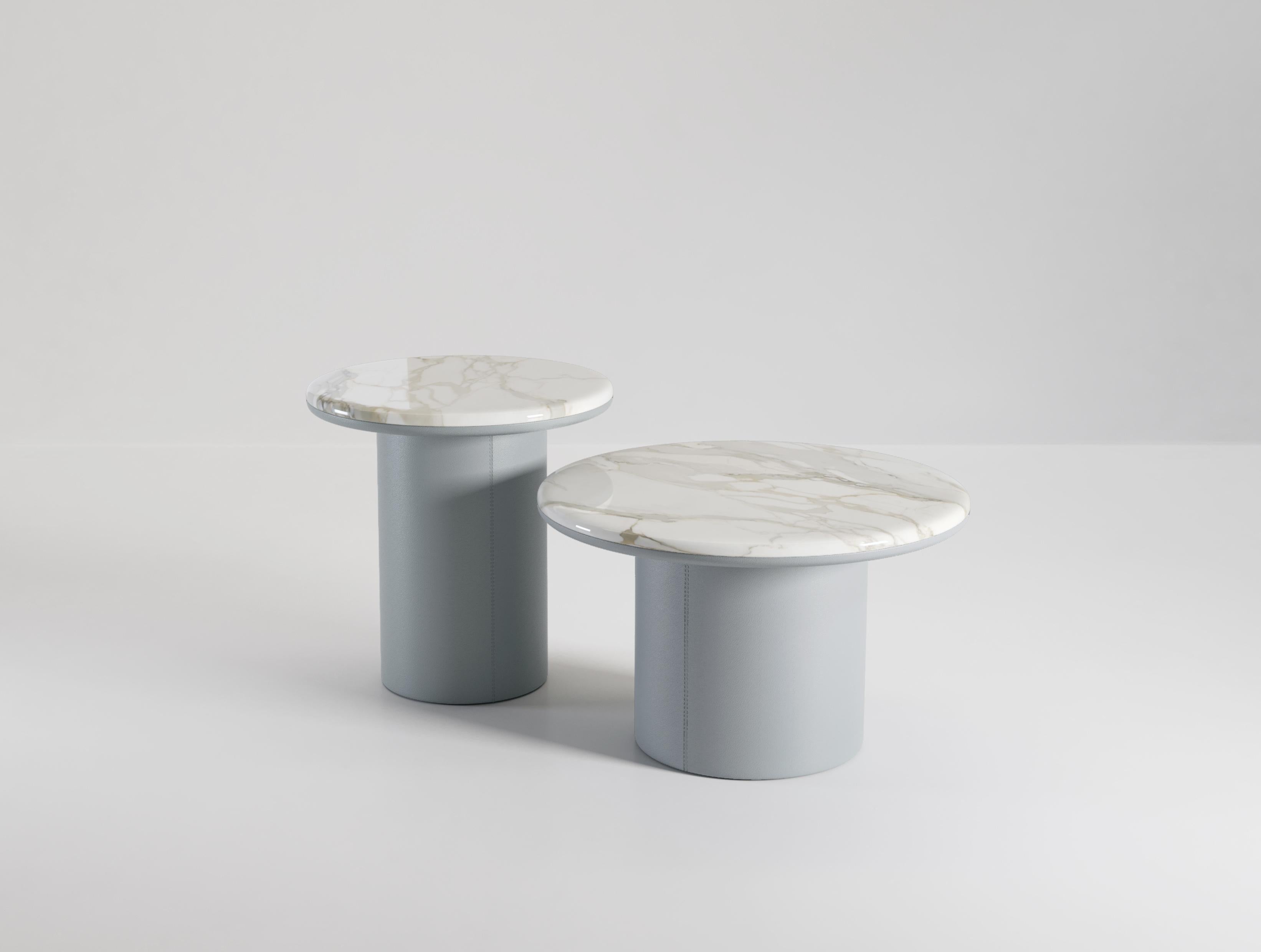 The Gemini coffee tables are characterised by the combination of materials on the top and bottom of the table. Leather wraps around the entire base and even continues up the underside of the table top. Half way around the top the leather stops and