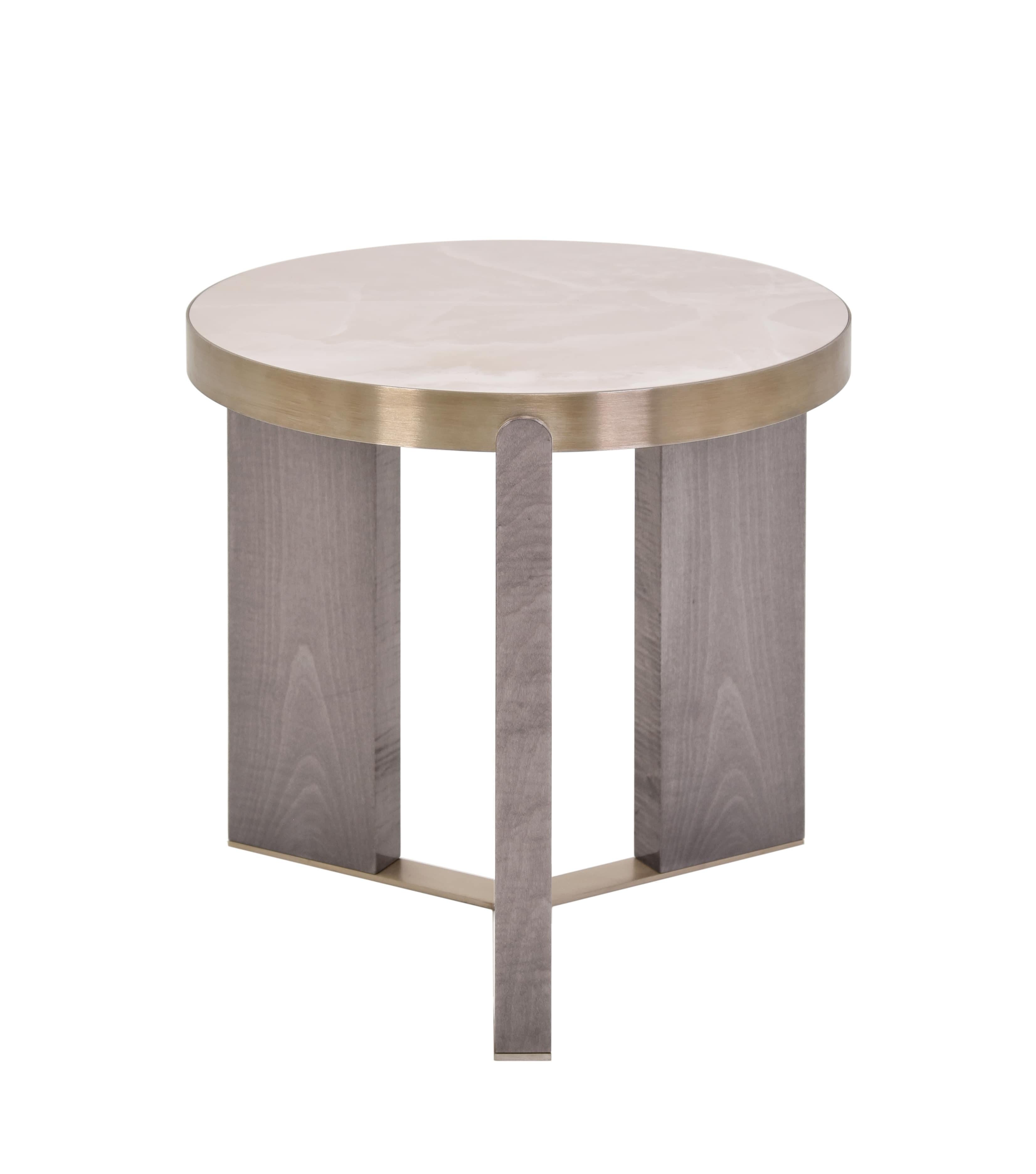 A study in balance and material contrast, this side table combines the warmth of oak with the subtle elegance of brushed brass. Its design is defined by three legs connected to each other, supporting a round top in Dekton material. The duality of