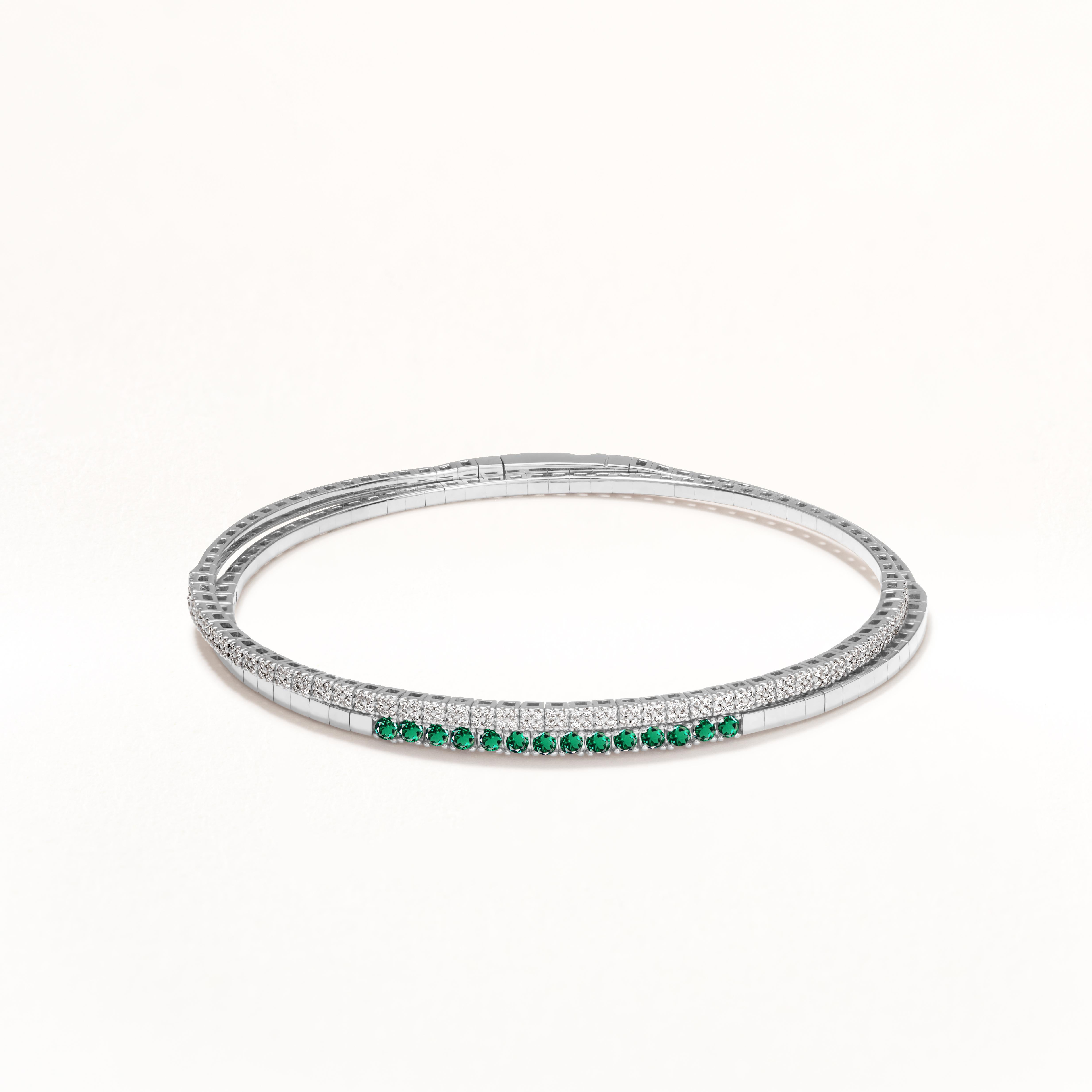 Elegant and feminine! Gemistry created this gorgeous rolling bangle bracelet set in 18K white gold with 176 round-full cut white diamonds and 14 round-cut emeralds arranged in graceful patterns, making it the ideal choice for your party outfits. The