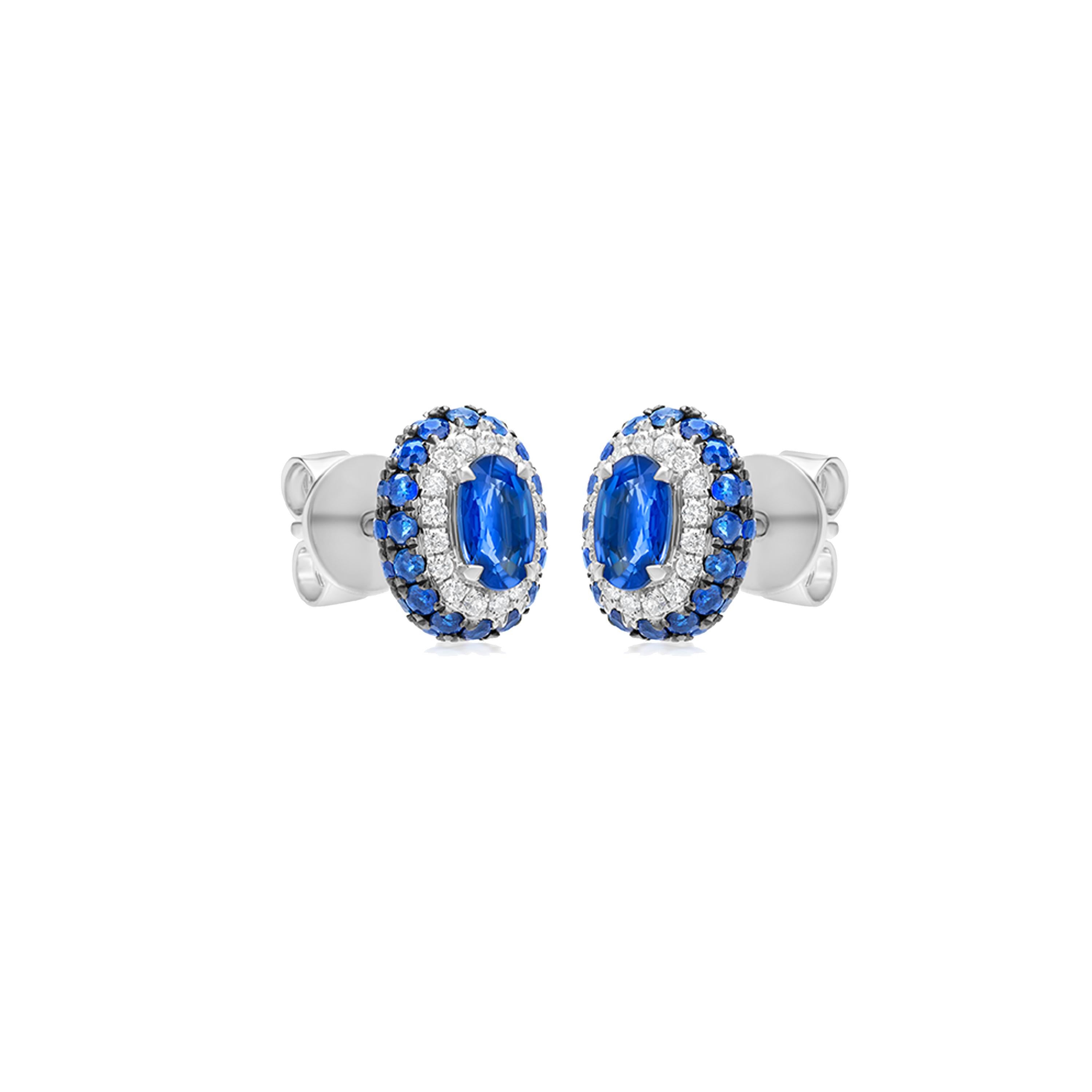 This lightweight yet heavily studded ear stud pair is manifested on an 18K White Gold with black rhodium pave.  Round full-cut White Diamonds are affixed on the stunning earring pair in a micro pave setting. Two oval-shaped Blue Sapphire stones are