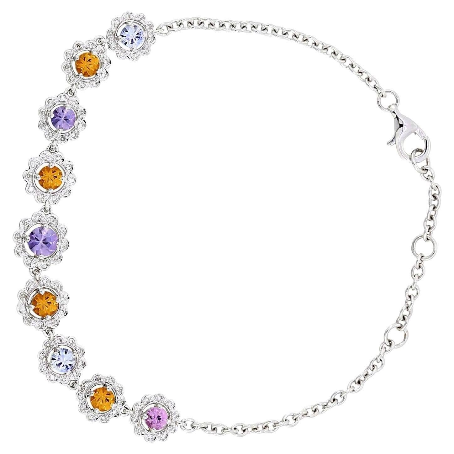 Discover the charm of this Multi-Gemstone Flower Bracelet in 18K White Gold. The bracelet features a delicate chain adorned with vibrant, round multi-colored sapphires arranged in a stunning floral pattern. Each petal is highlighted by sparkling