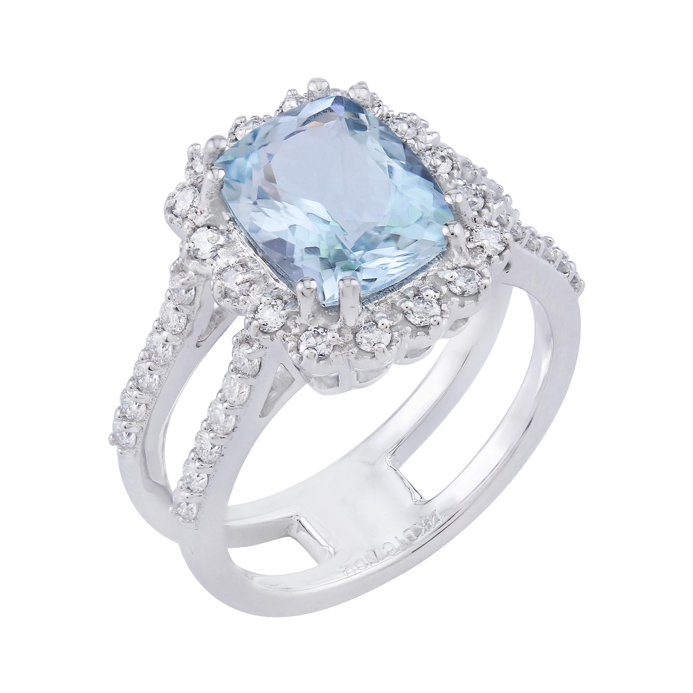 Gönnen Sie sich die ruhige Schönheit dieses Rings mit geteiltem Schaft aus 14 Karat Weißgold mit Aquamarin und weißem Diamant. Das Herzstück ist ein bezaubernder Aquamarin, der seinen leuchtend blauen Farbton zur Geltung bringt und durch einen Kranz