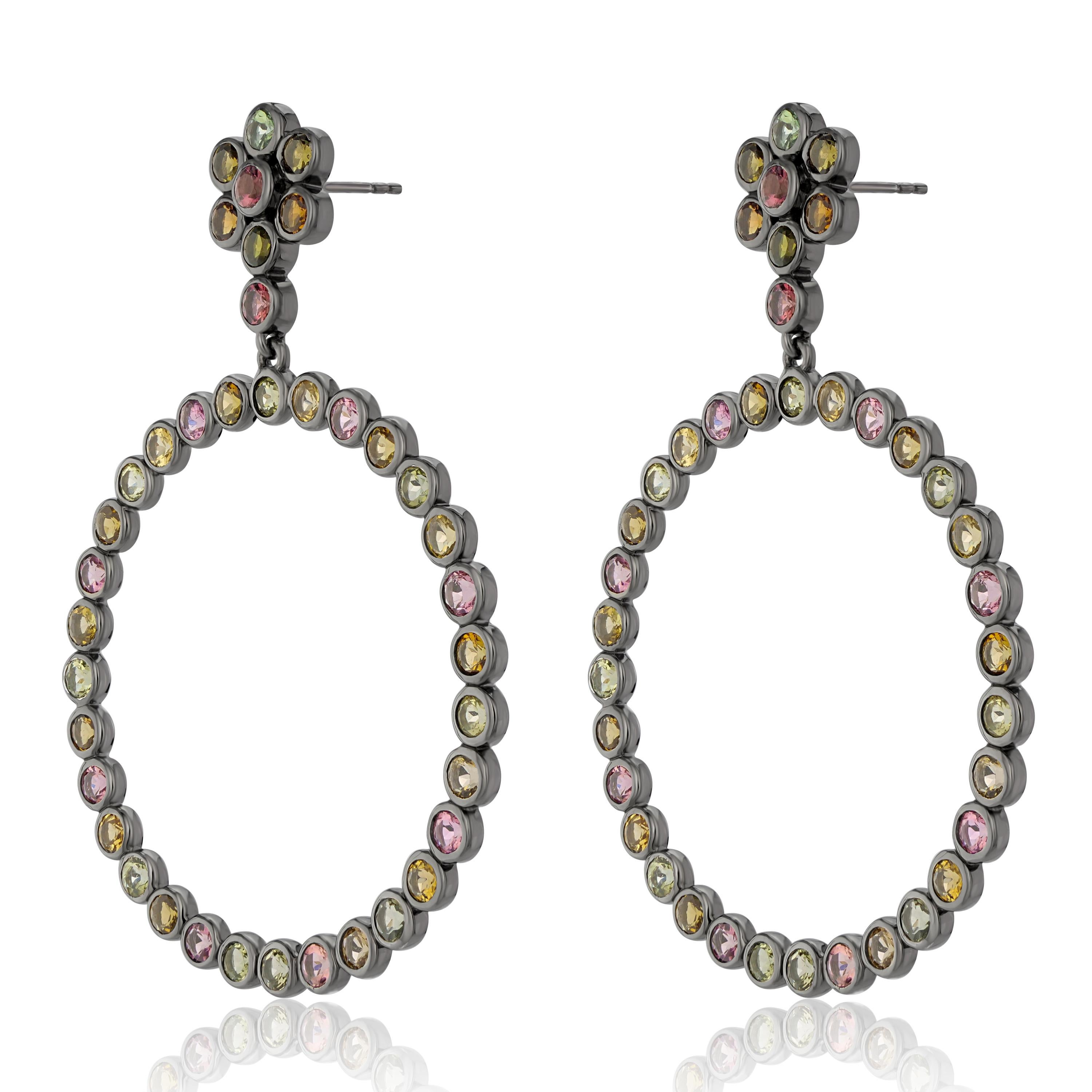 Lleva un arco iris en los lóbulos de las orejas. Estos pendientes de mujer presentan turmalinas redondas de 3 mm 9,50 qt Tw dispuestas en un diseño floral y circular de espacio abierto. Estos pendientes están fabricados en auténtica plata de ley sin