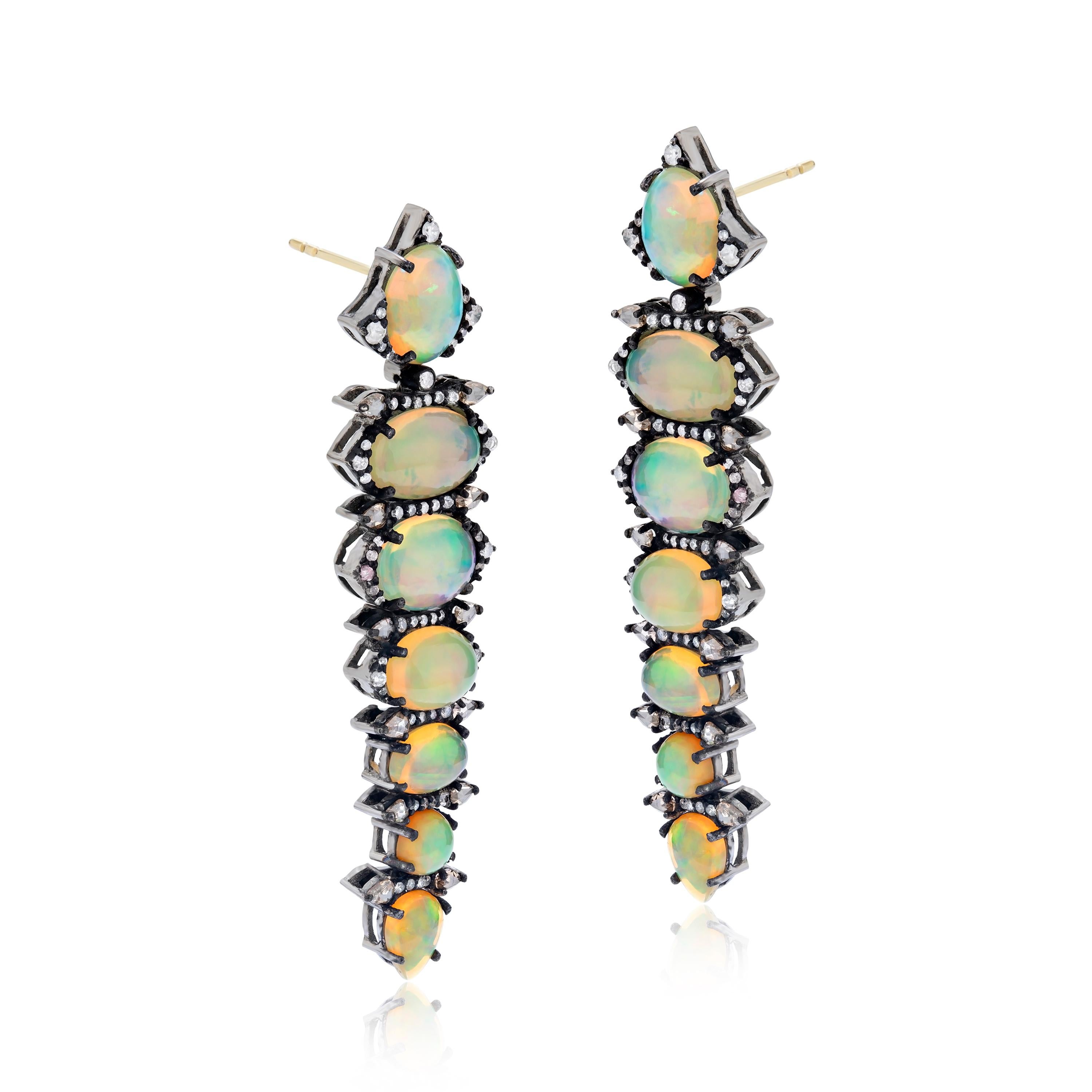 This Gemistry, Victorian 11.64 Ct. T.W. Diamond and Ethiopian Opal Drop Earrings features row of graduating drops of shinning round , oval and pear Ethiopian opals enclosed by pave diamond halos on a black rhodium polished 18k/925 surface. This